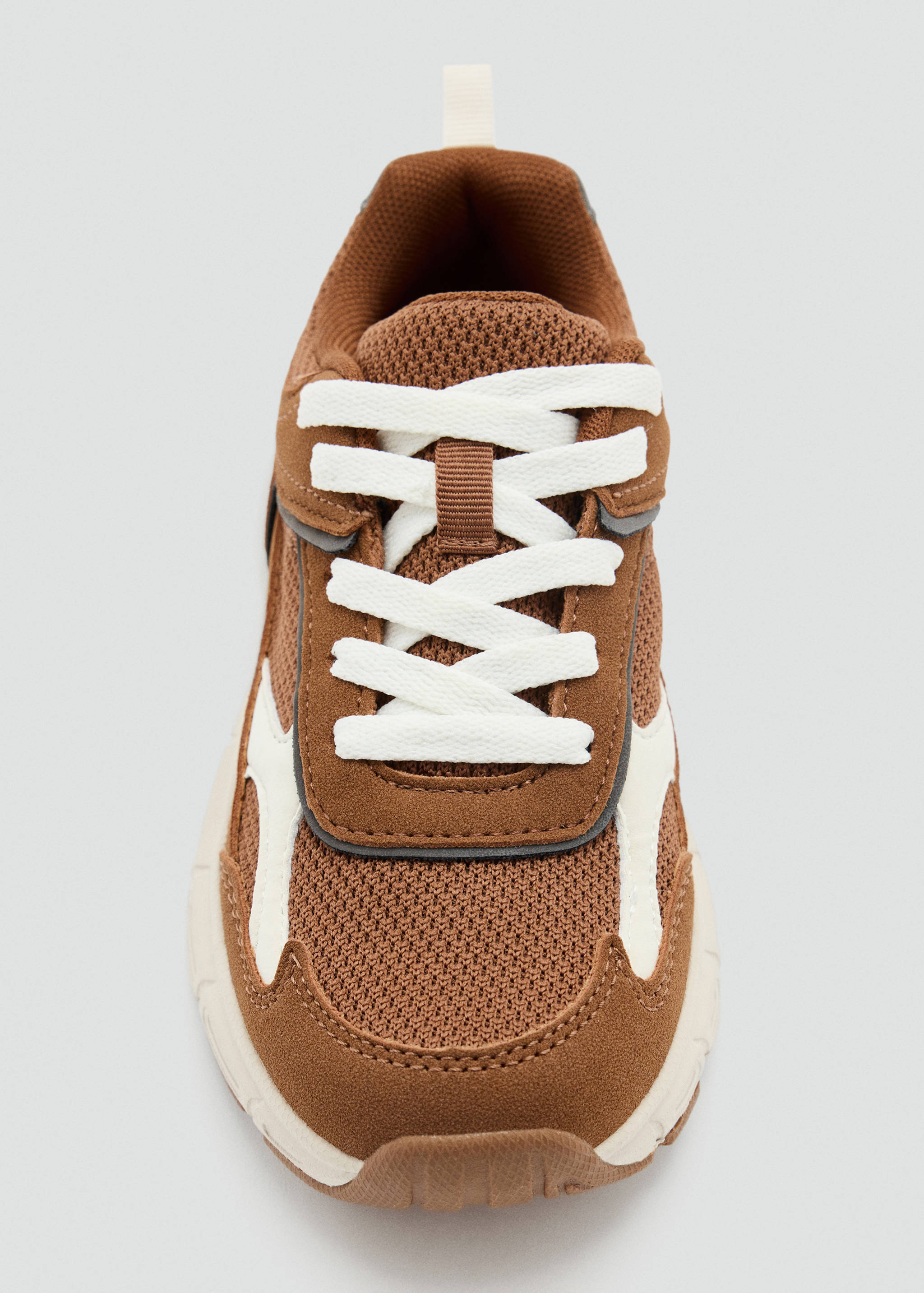 Brown children's trainers with white laces and contrasting panels.