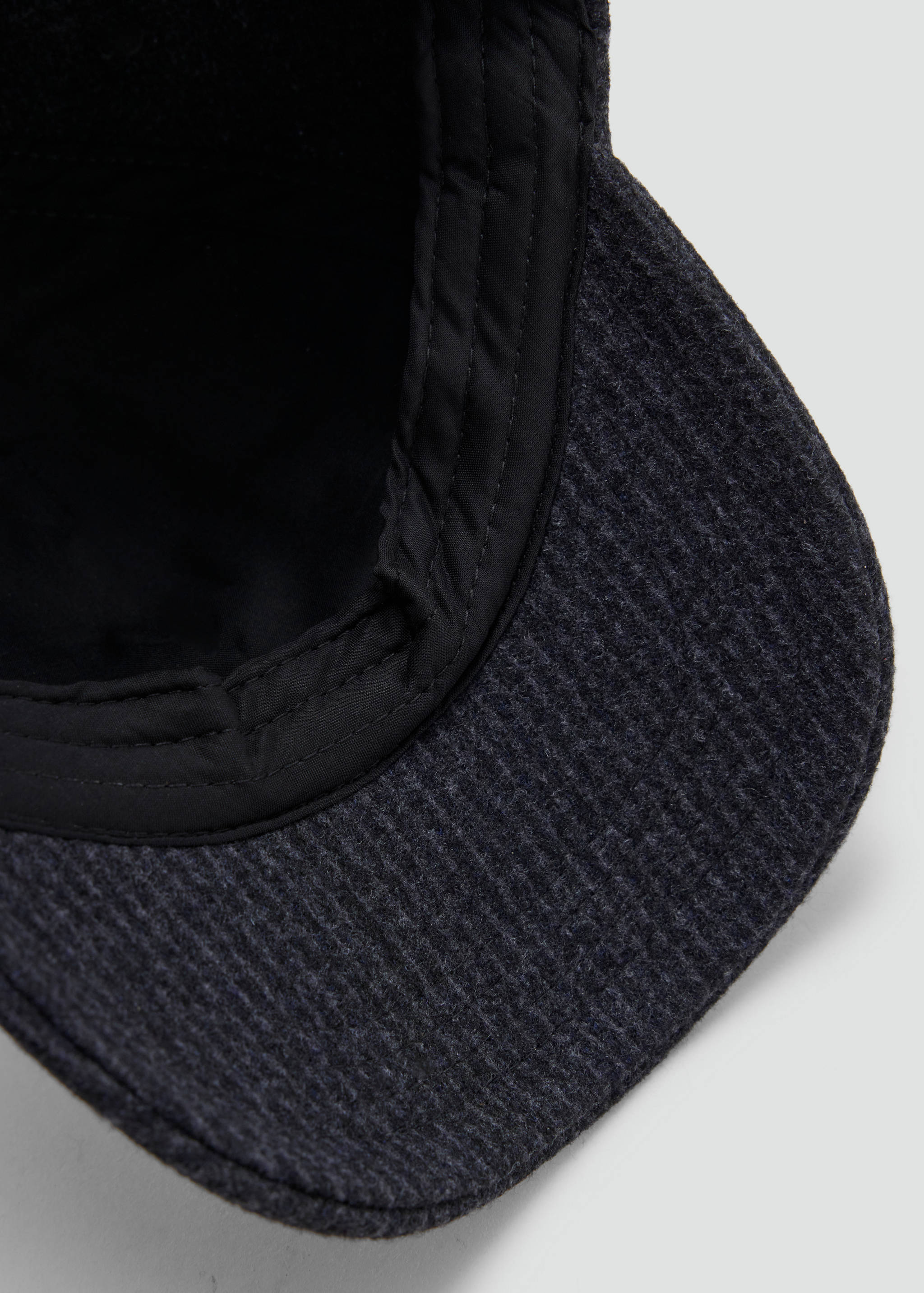 Primer plano del interior de una gorra texturizada en gris oscuro.
