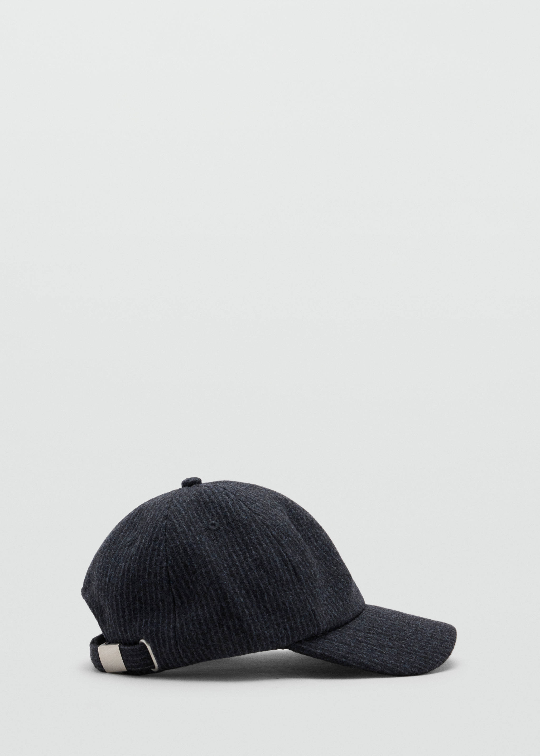 Gorra texturizada en gris oscuro con visera curva y tira ajustable con hebilla en tono plateado.
