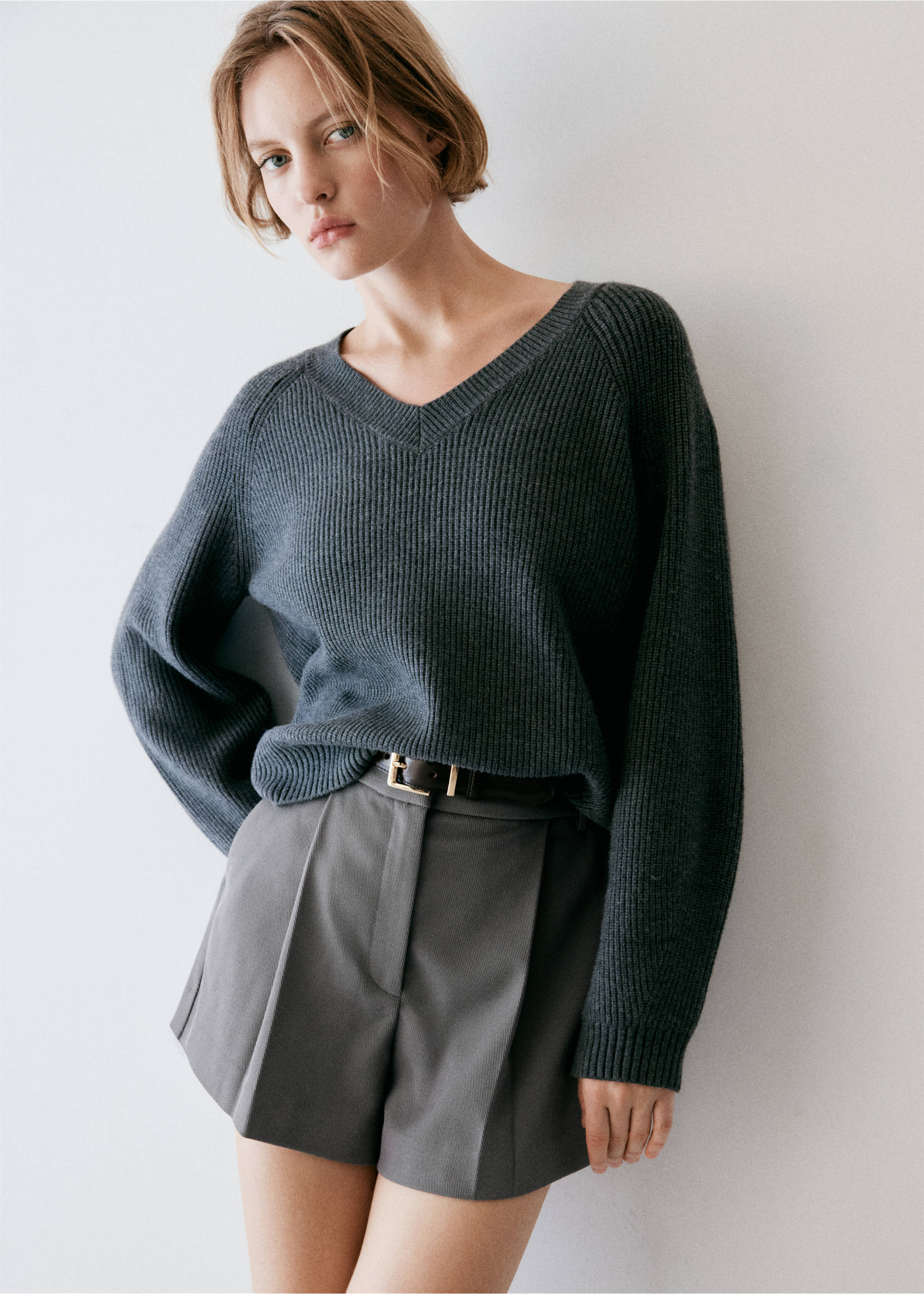 Grey pleated shorts worn with a dark grey ribbed V-neck jumper., Grey. Ref: 37094775-01.