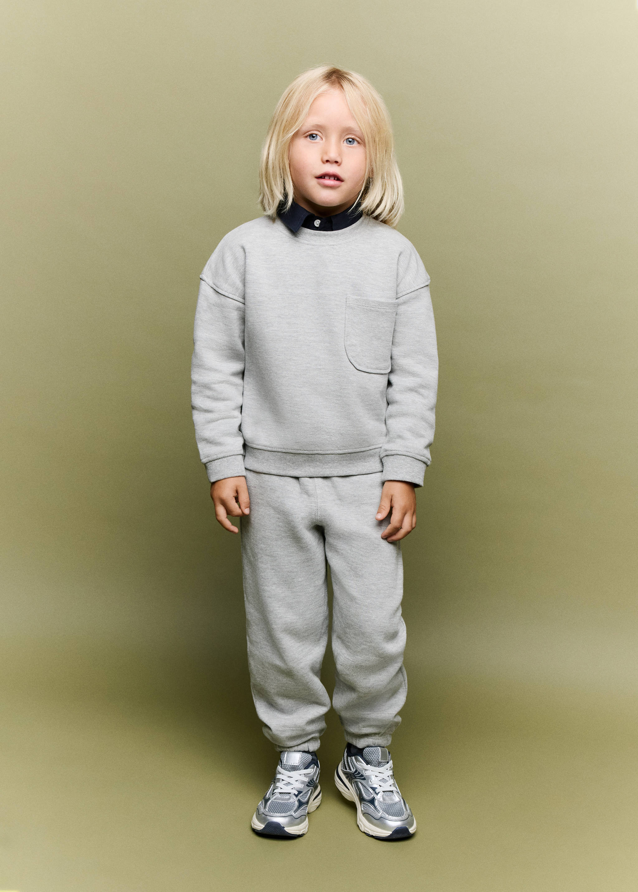 Grey joggers worn with a matching sweatshirt and trainers
