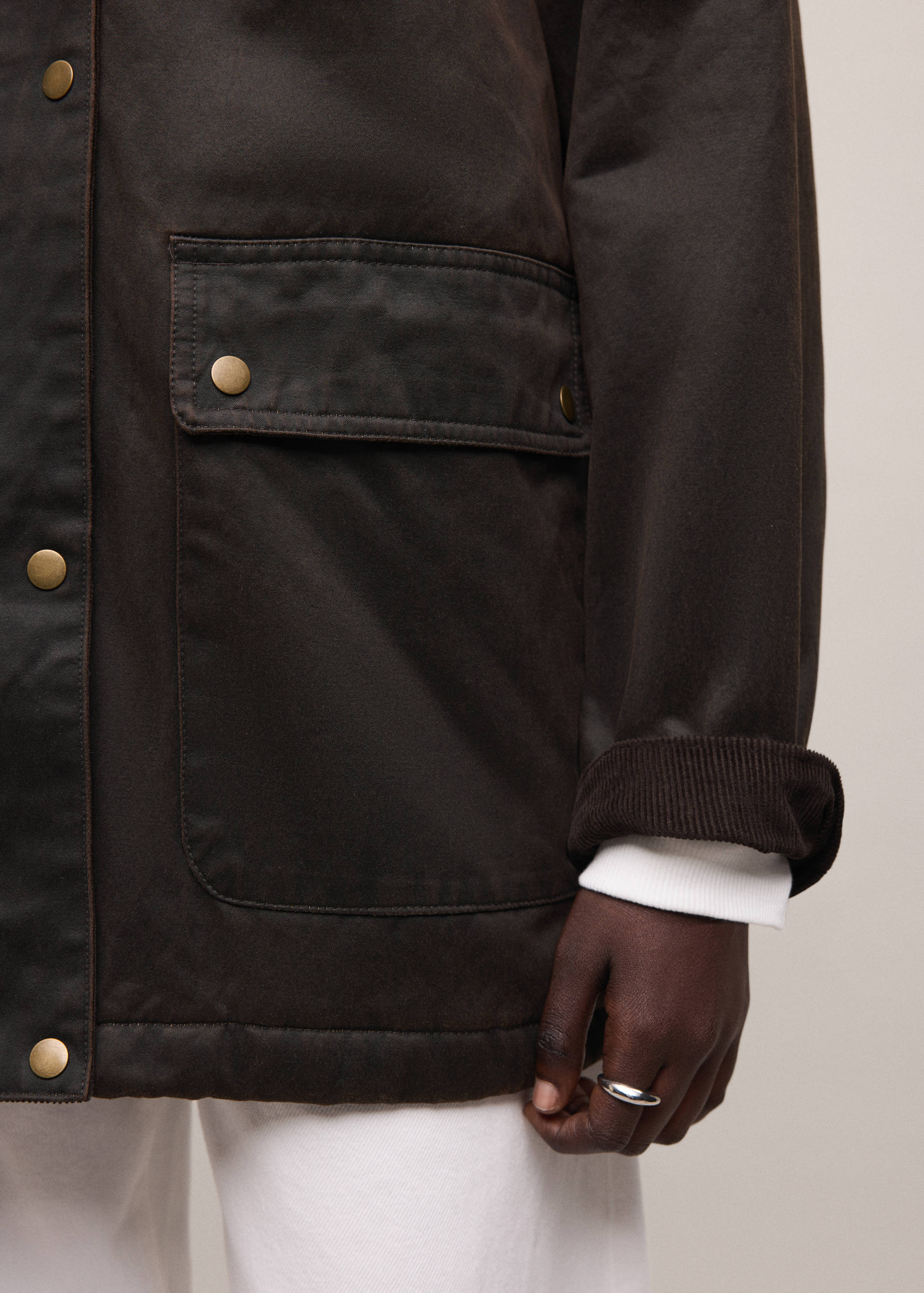 Dark brown parka with snap buttons, patch pockets and corduroy-lined cuffs.