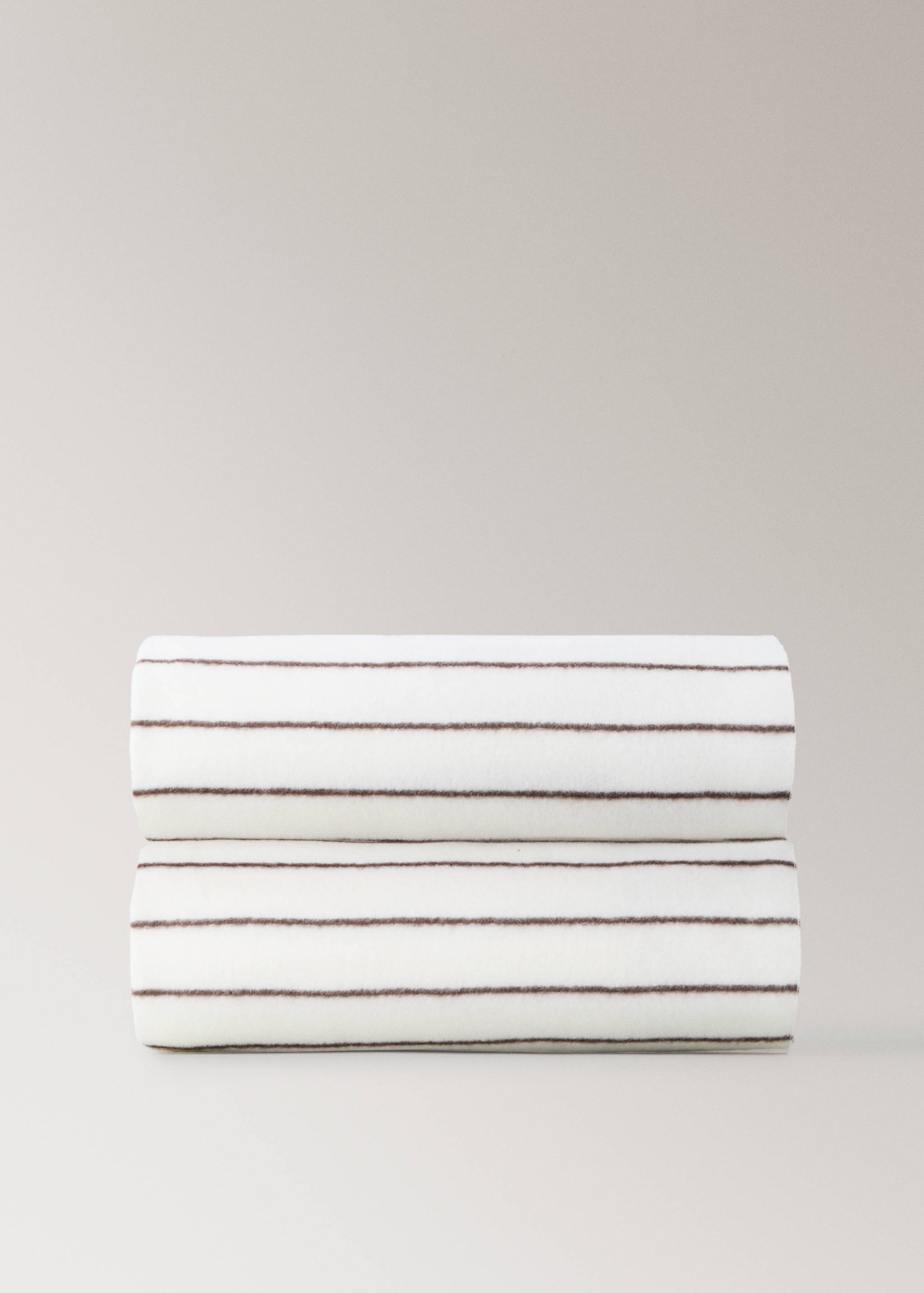 White blanket with thin brown horizontal stripes, neatly folded.