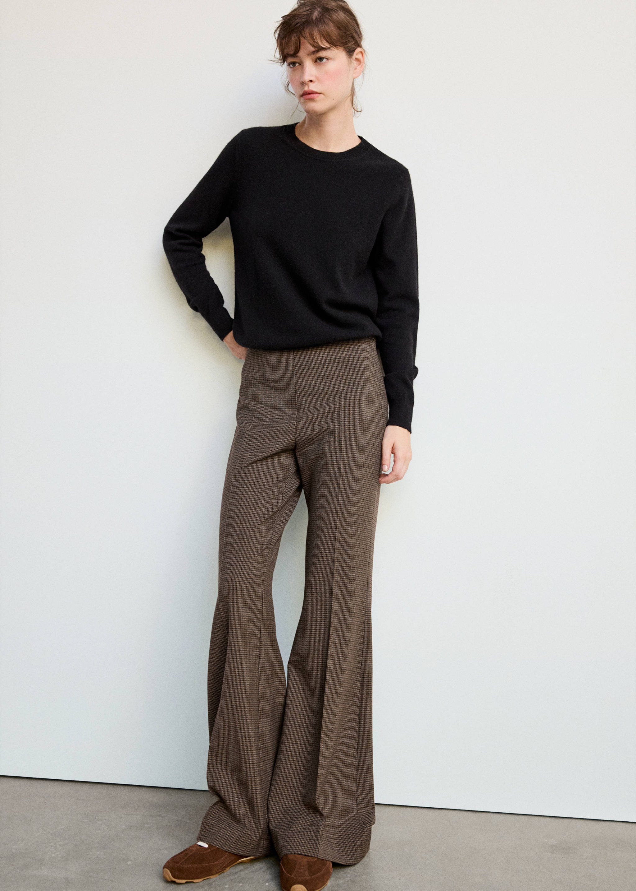 Brown houndstooth trousers with a flared silhouette.