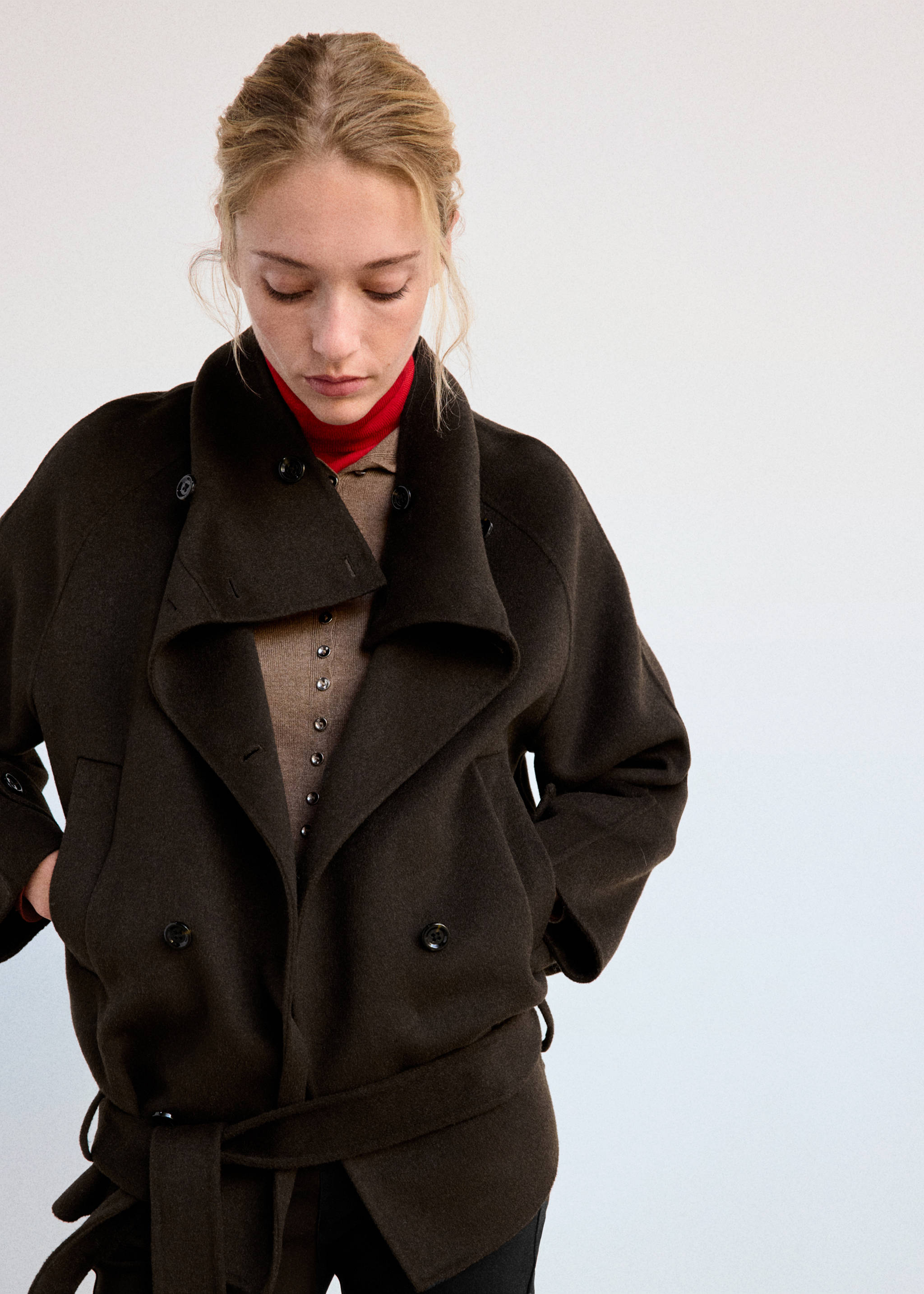 Dark brown cropped jacket featuring a wide collar, double-breasted button fastening and a matching waist belt.