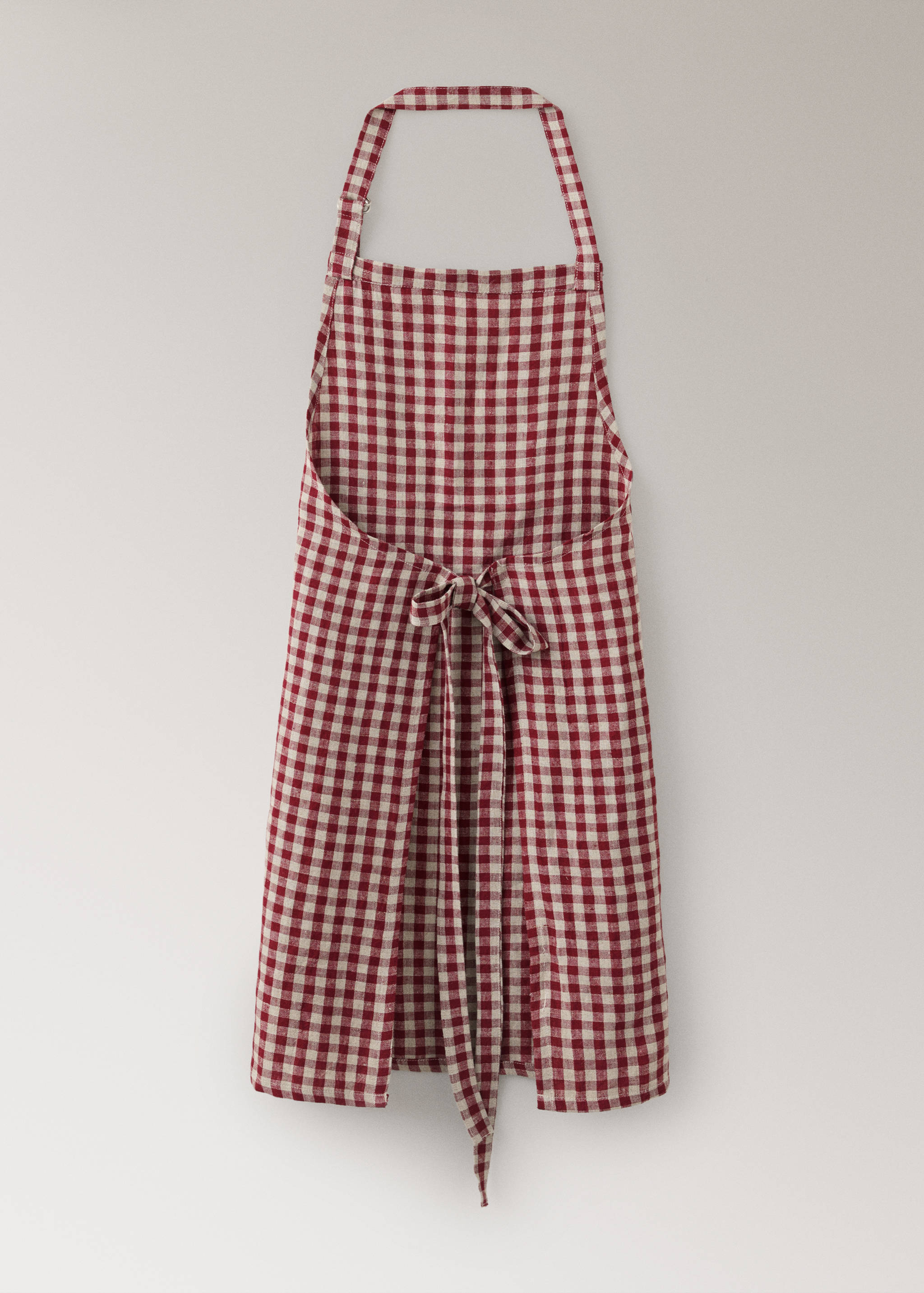 Delantal con estampado de cuadros vichy en rojo y blanco y tiras para anudar en la cintura.