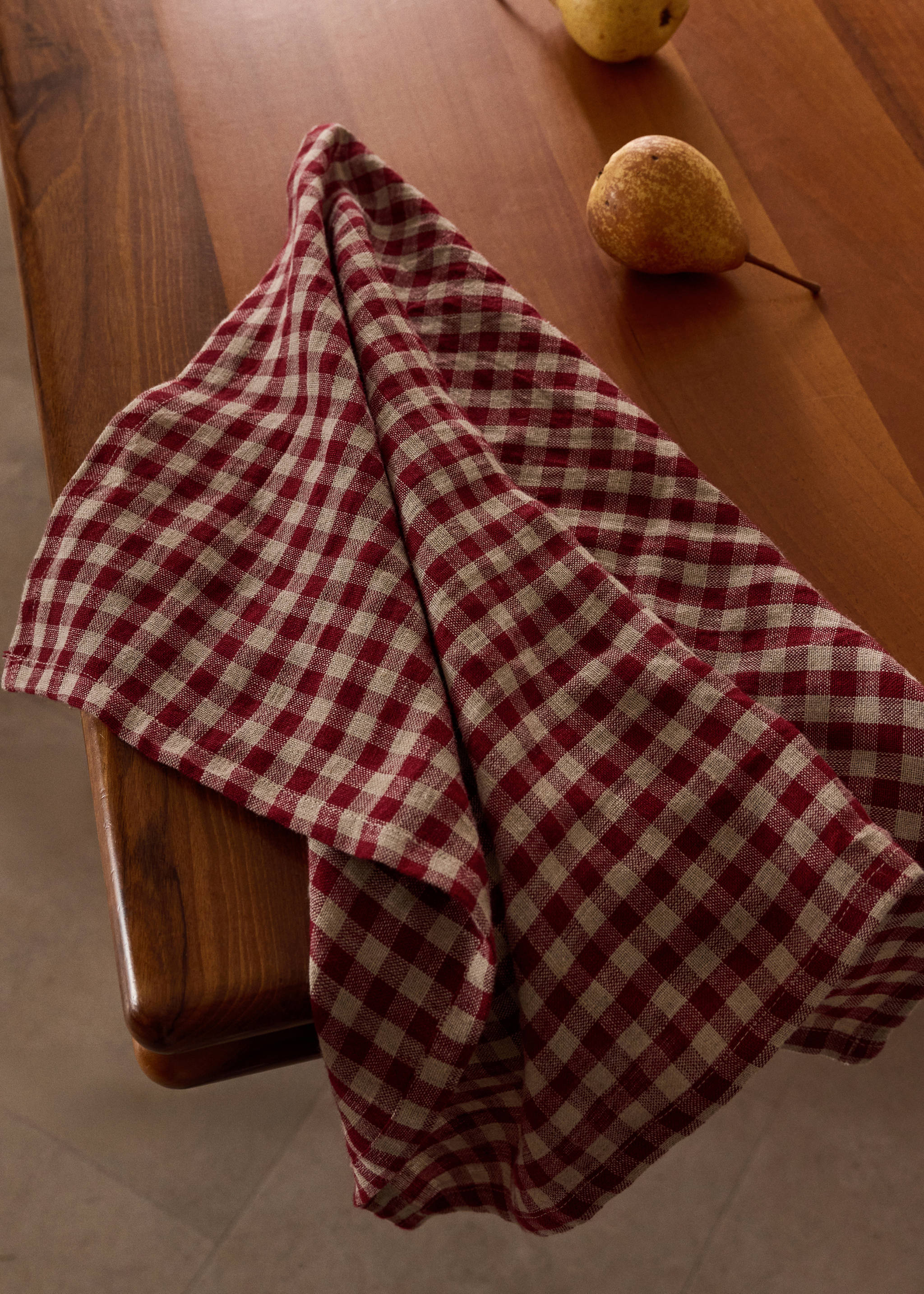 Red and beige checked kitchen cloth on a wooden table.