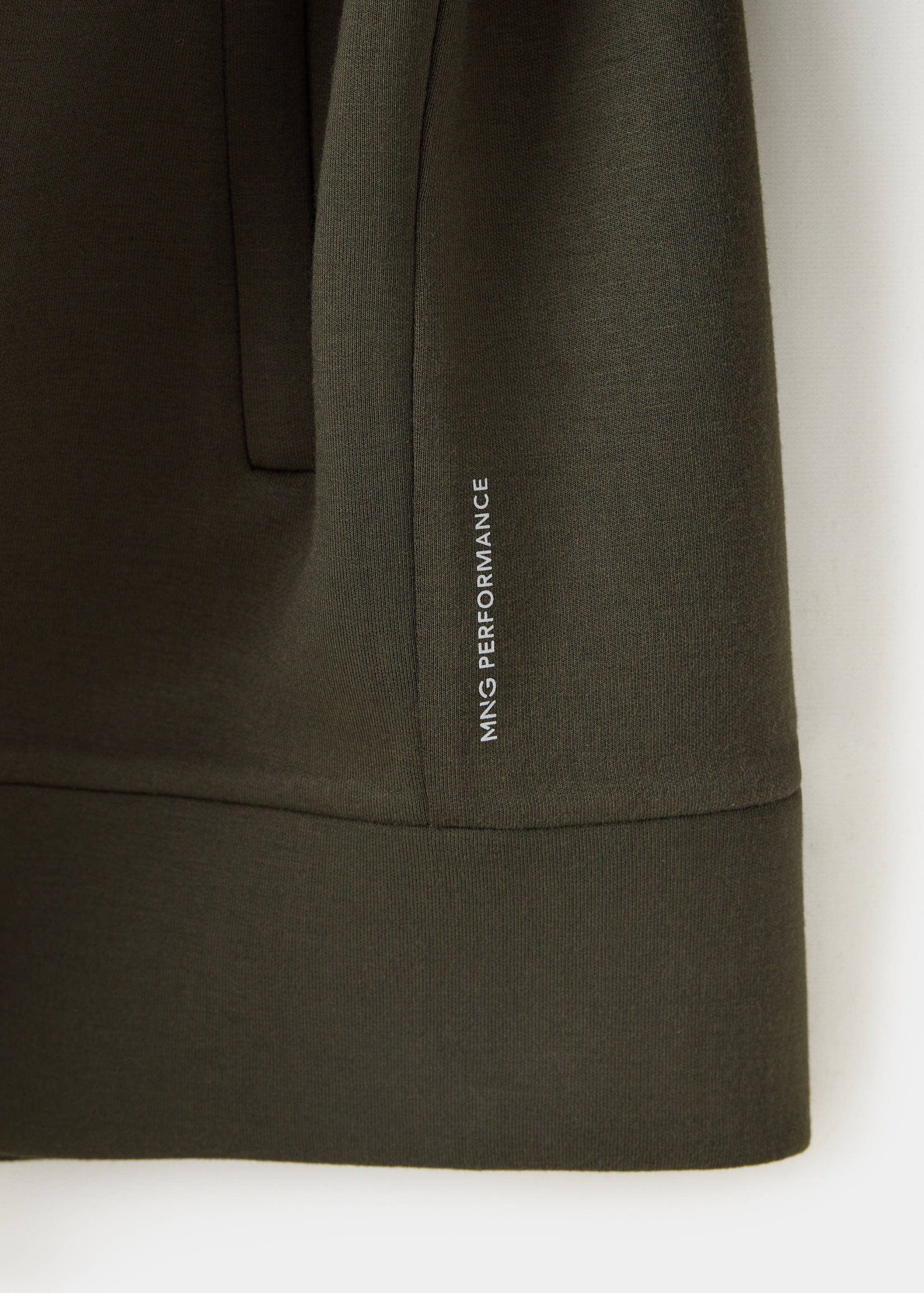 Close-up of olive green sweatshirt fabric with white logo print.