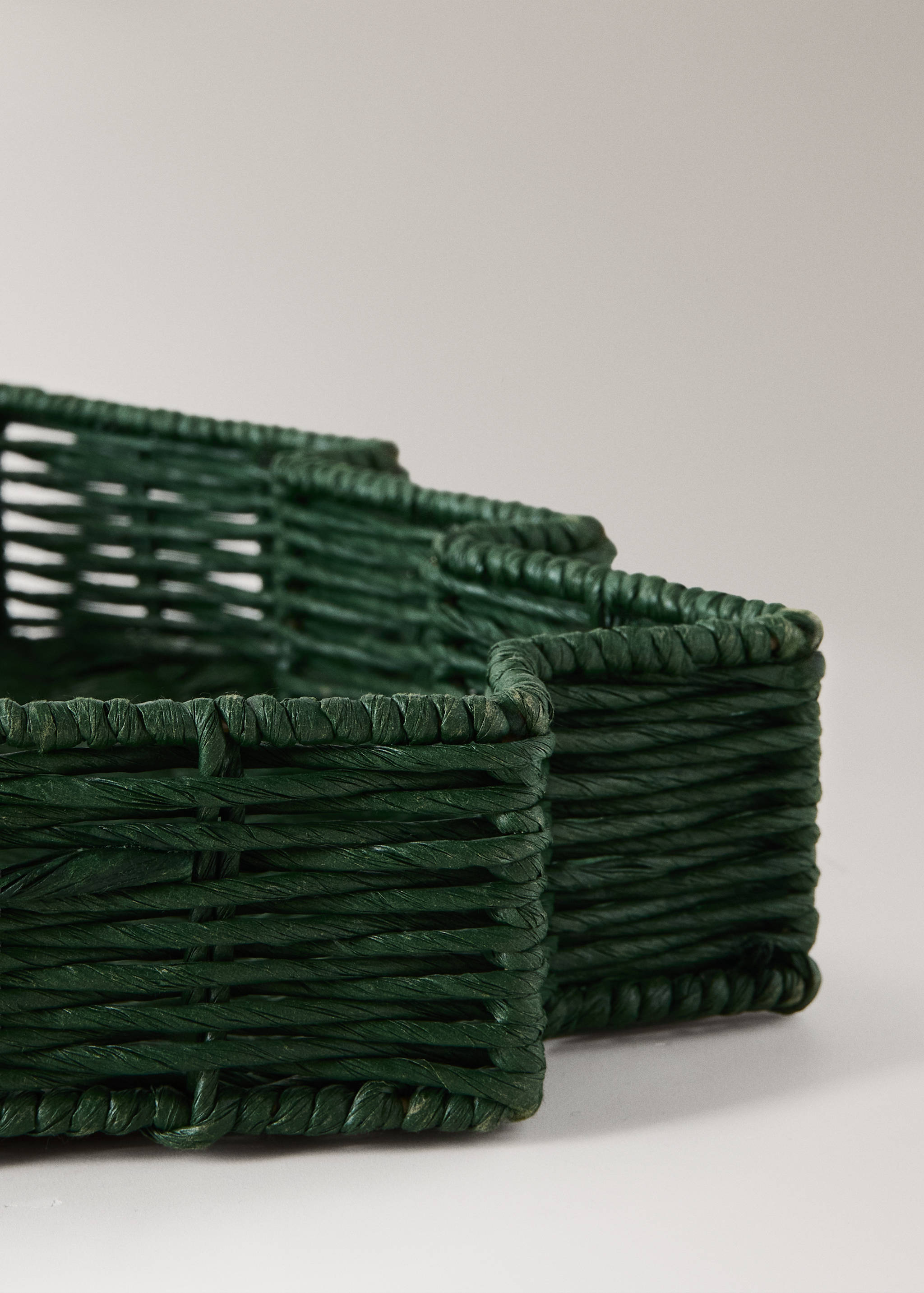 Close-up of a dark green woven basket detail.