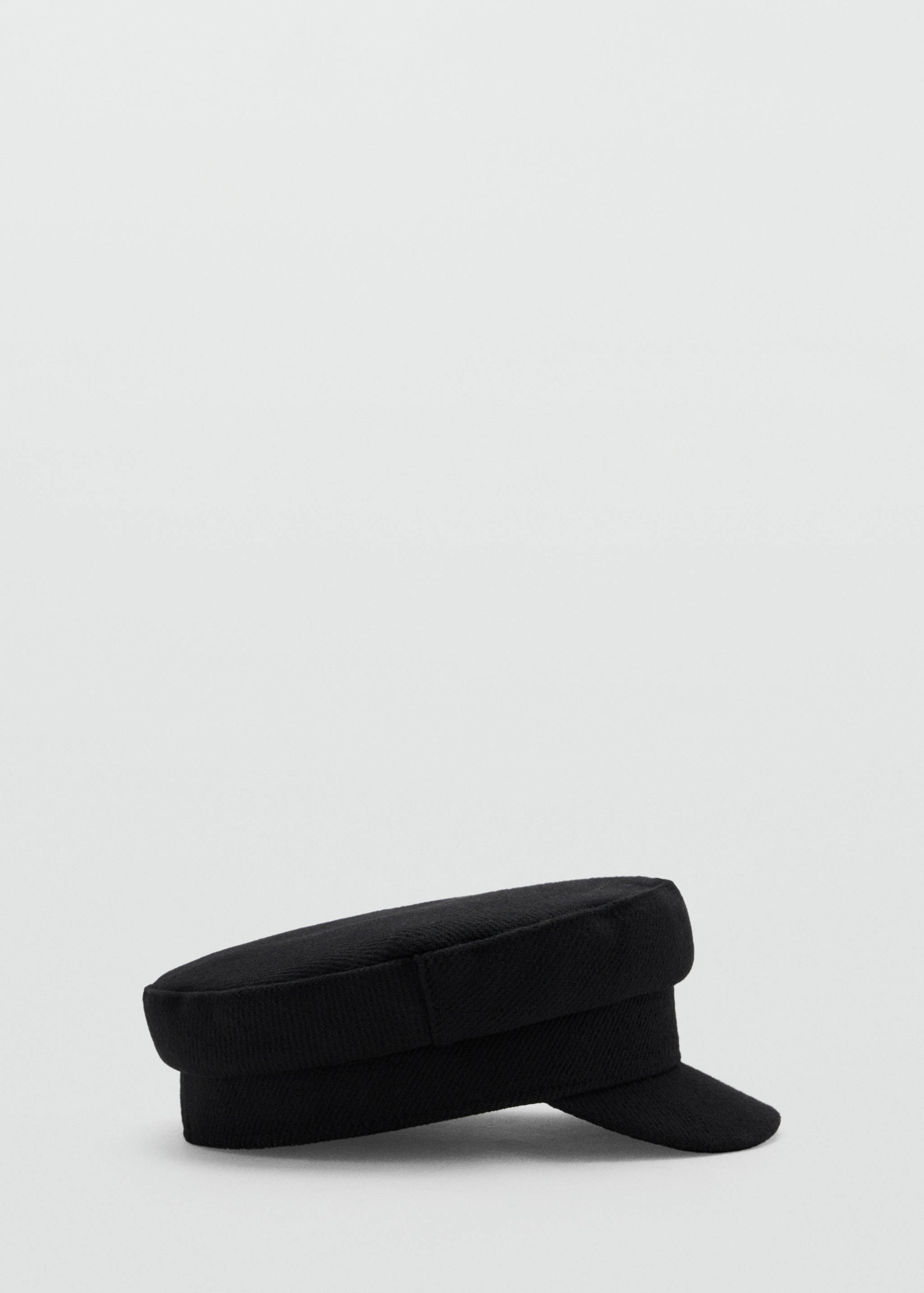 Black baker boy cap with a flat top and short curved visor.