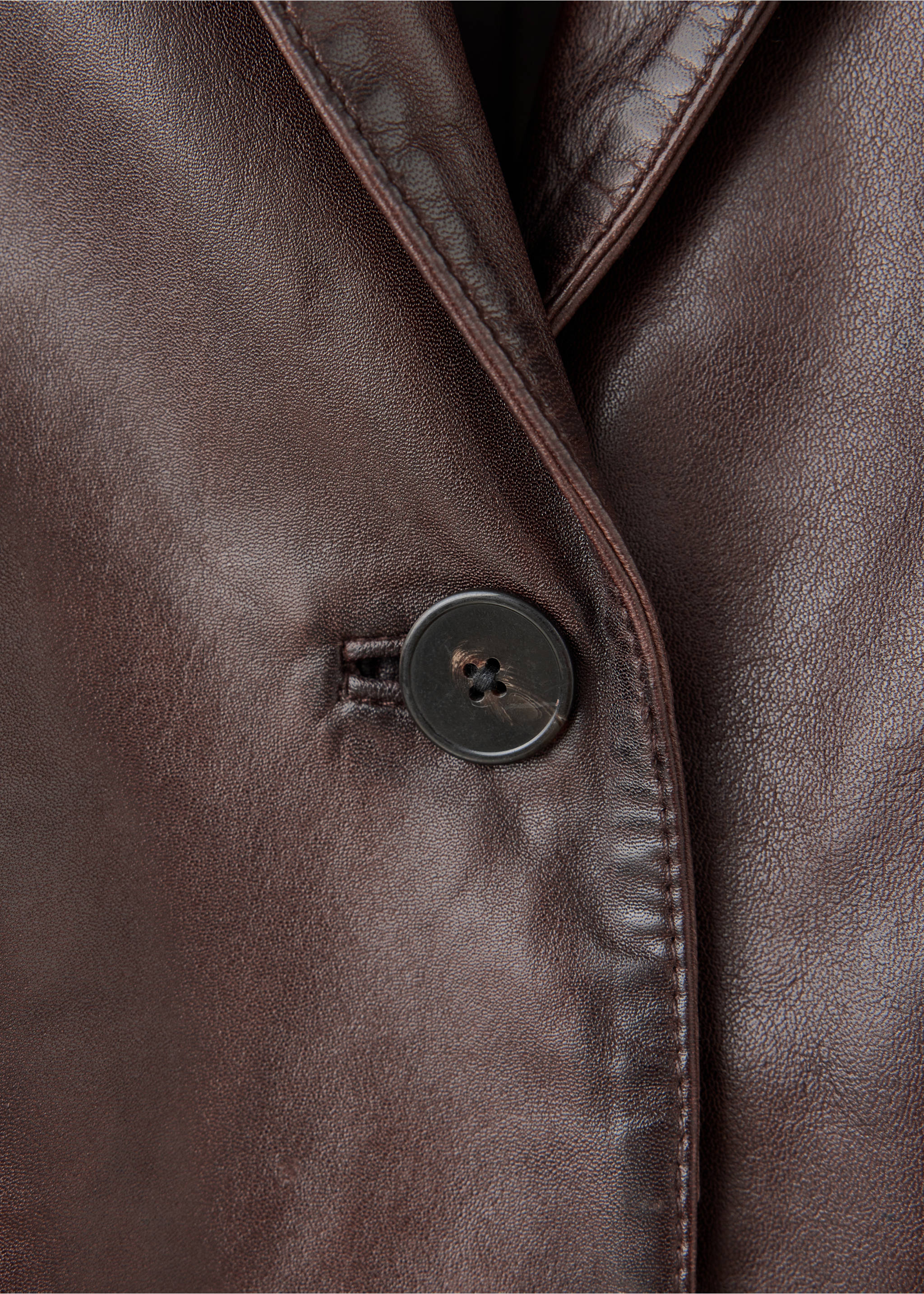 Close-up of a dark brown leather blazer showing the lapel and button detail., Brown. Ref: 37097773-00.