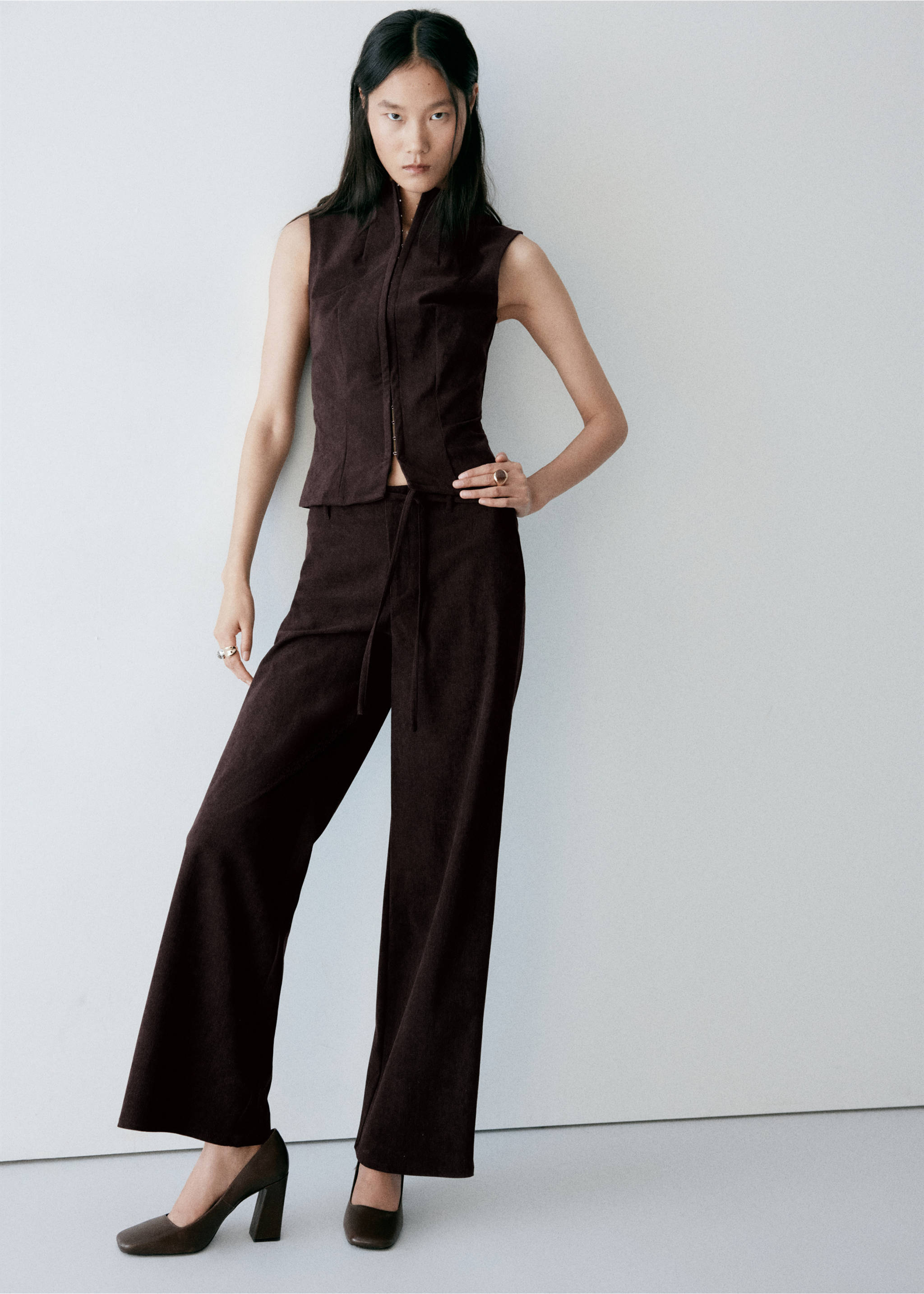 Dark brown sleeveless waistcoat with high collar and front zip, worn with matching trousers., Chocolate. Ref: 37097777-00.