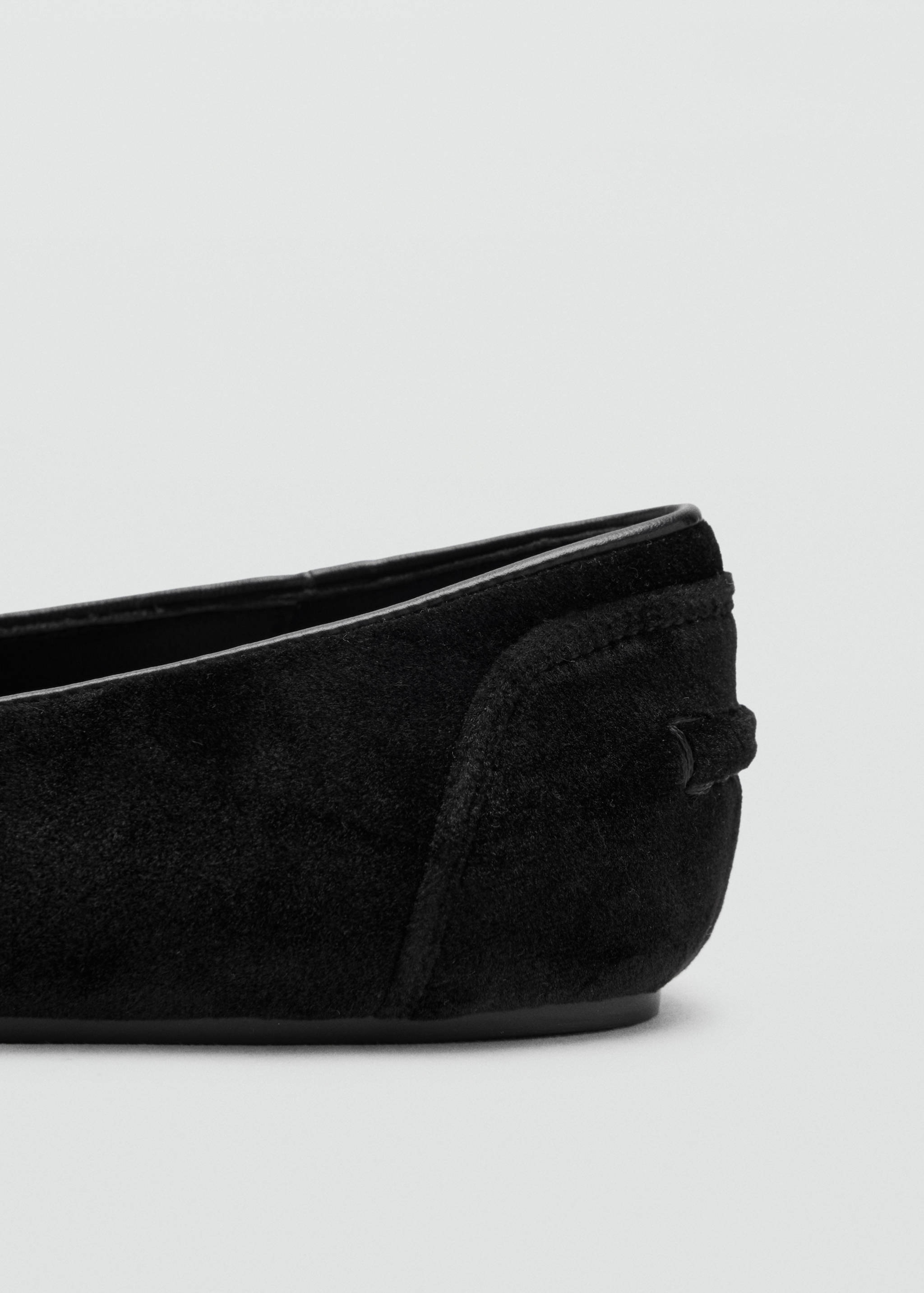 Close-up of the heel detail of a black shoe.