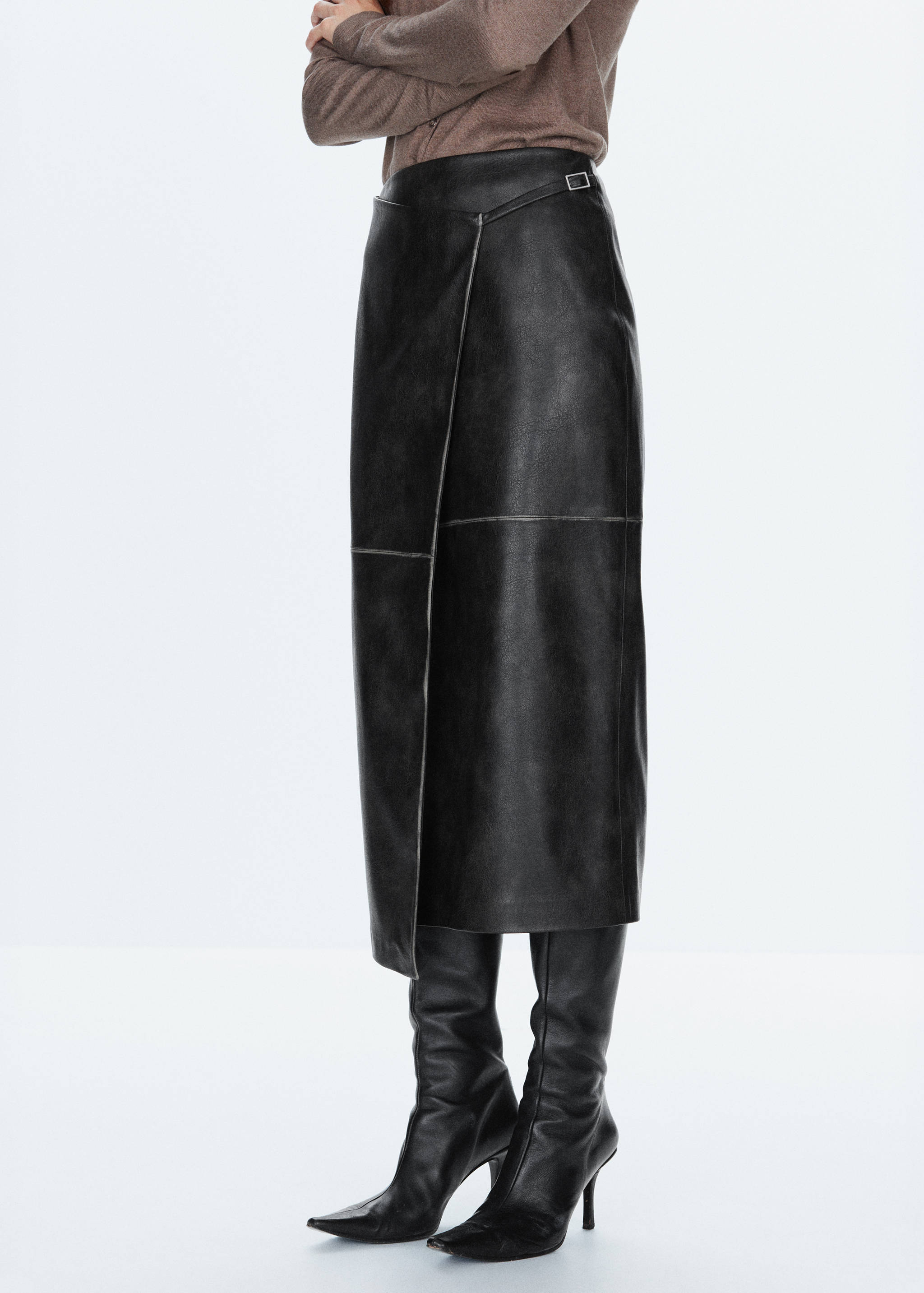 Black asymmetric wrap midi skirt with a waist buckle and visible seams.