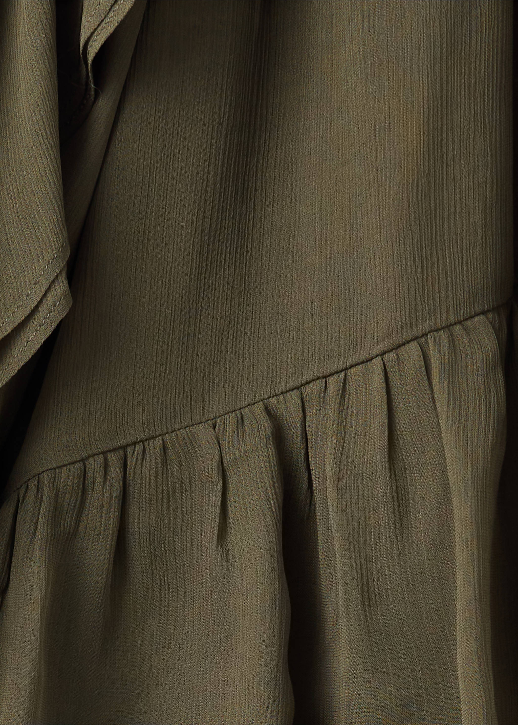 Close-up of textured olive green blouse fabric with a gathered tier detail., Green. Ref: 37097788-00.