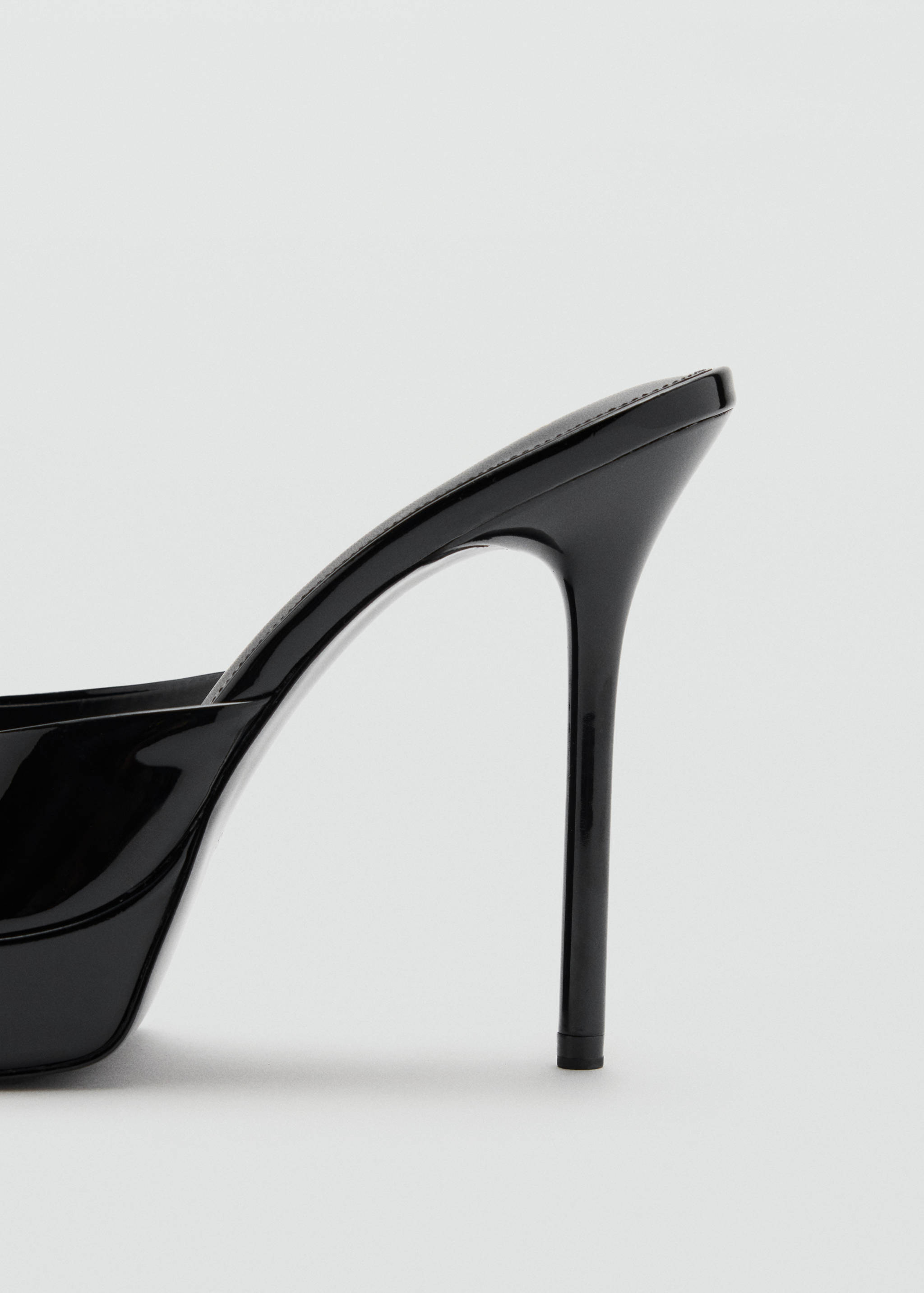 Close-up of a black patent sandal heel.
