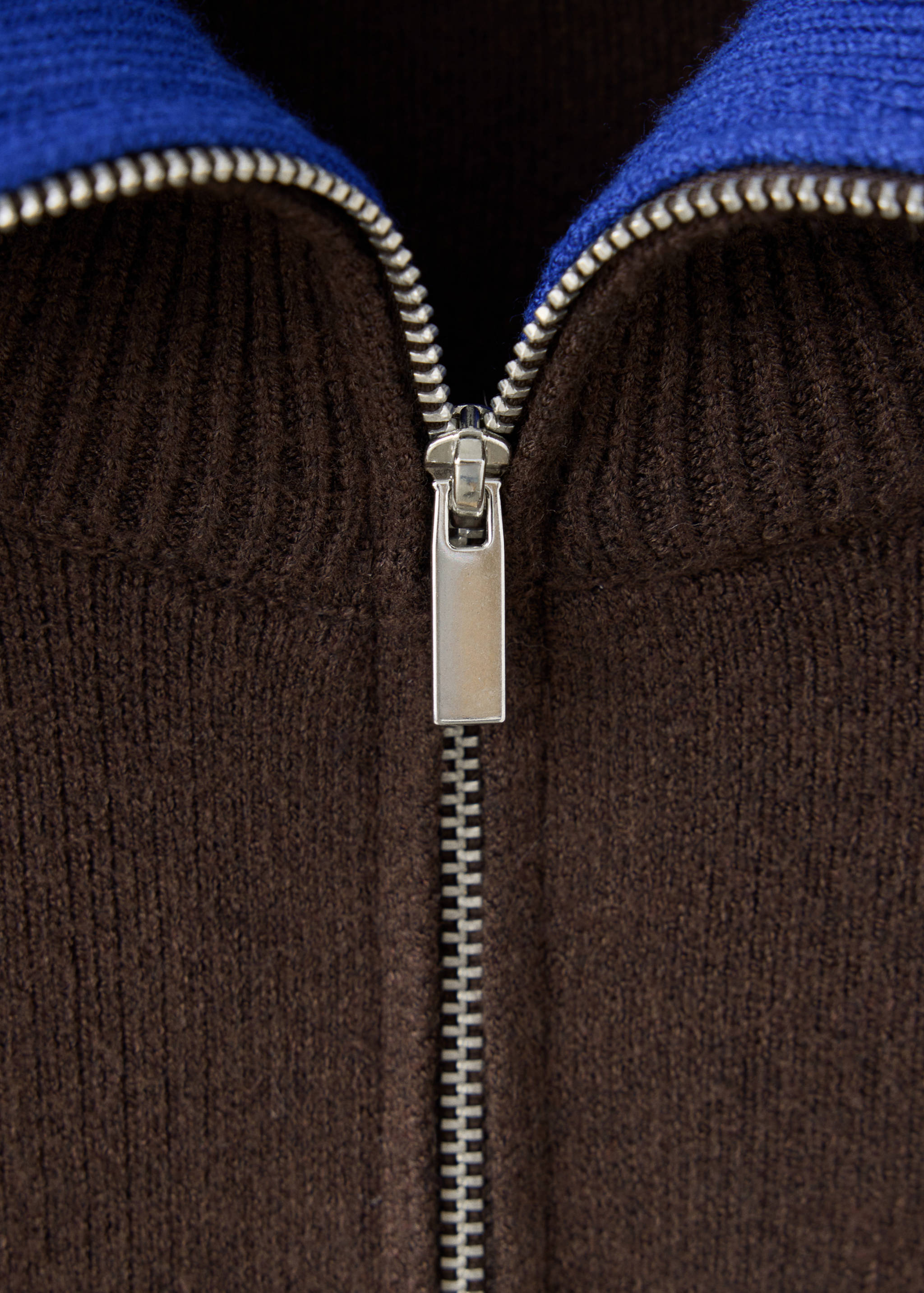 Brown knitted jacket zip detail with a bright blue inner collar