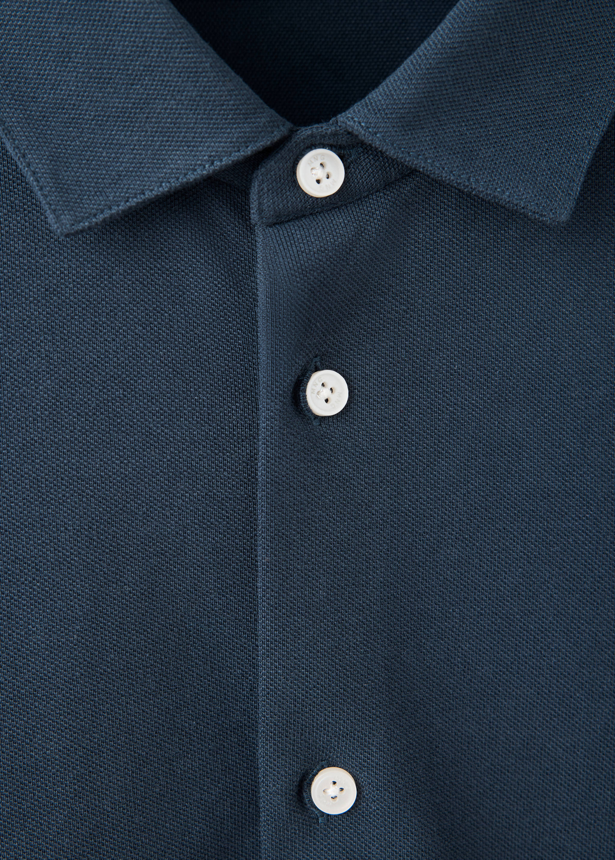 Close-up of a dark blue polo shirt collar and button placket.