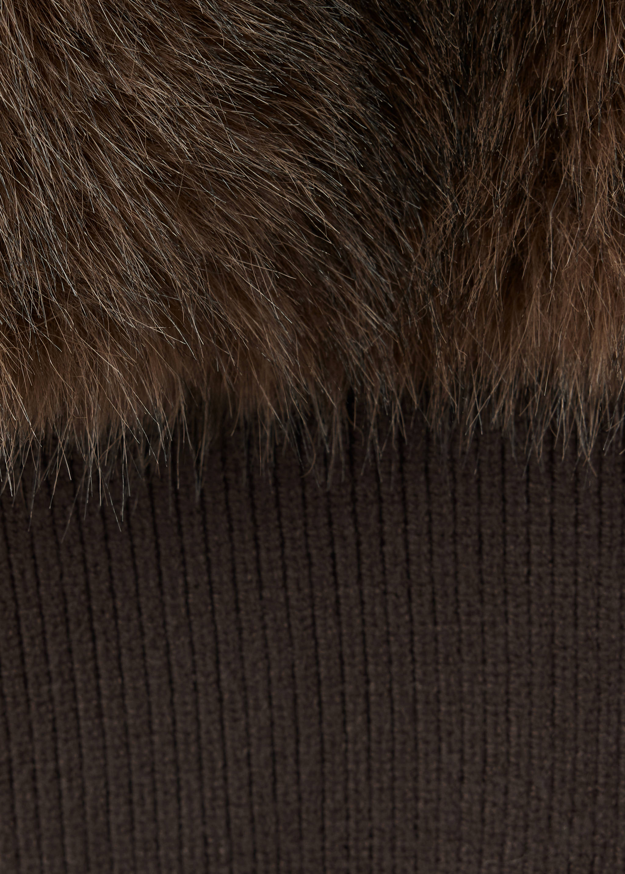 Close-up of a brown jacket showing textured faux-fur and ribbed knit.