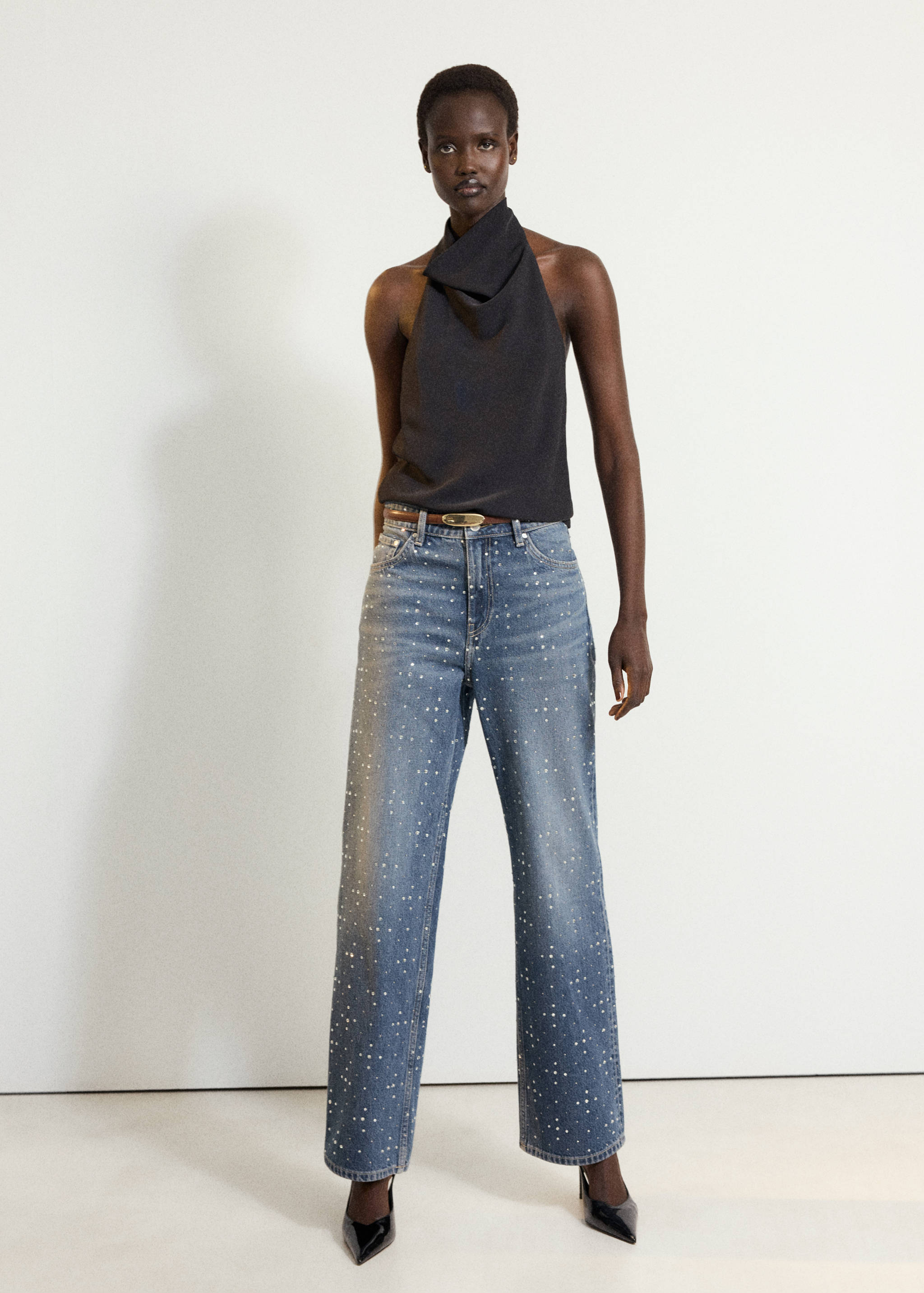 Blue embellished straight-leg denim trousers styled with a halter top.