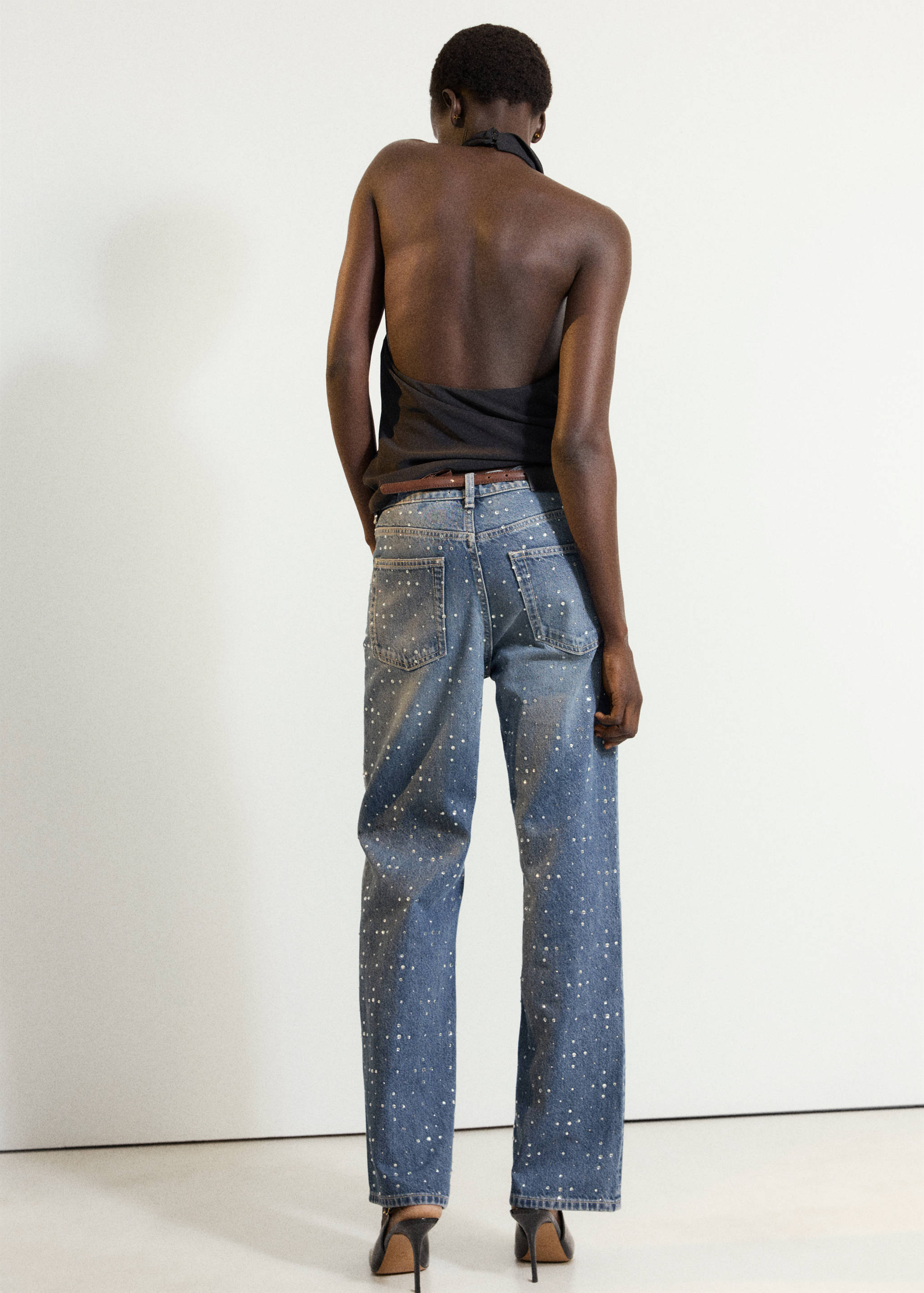 Crystal-embellished blue denim trousers in a straight-leg fit, shown from the back.