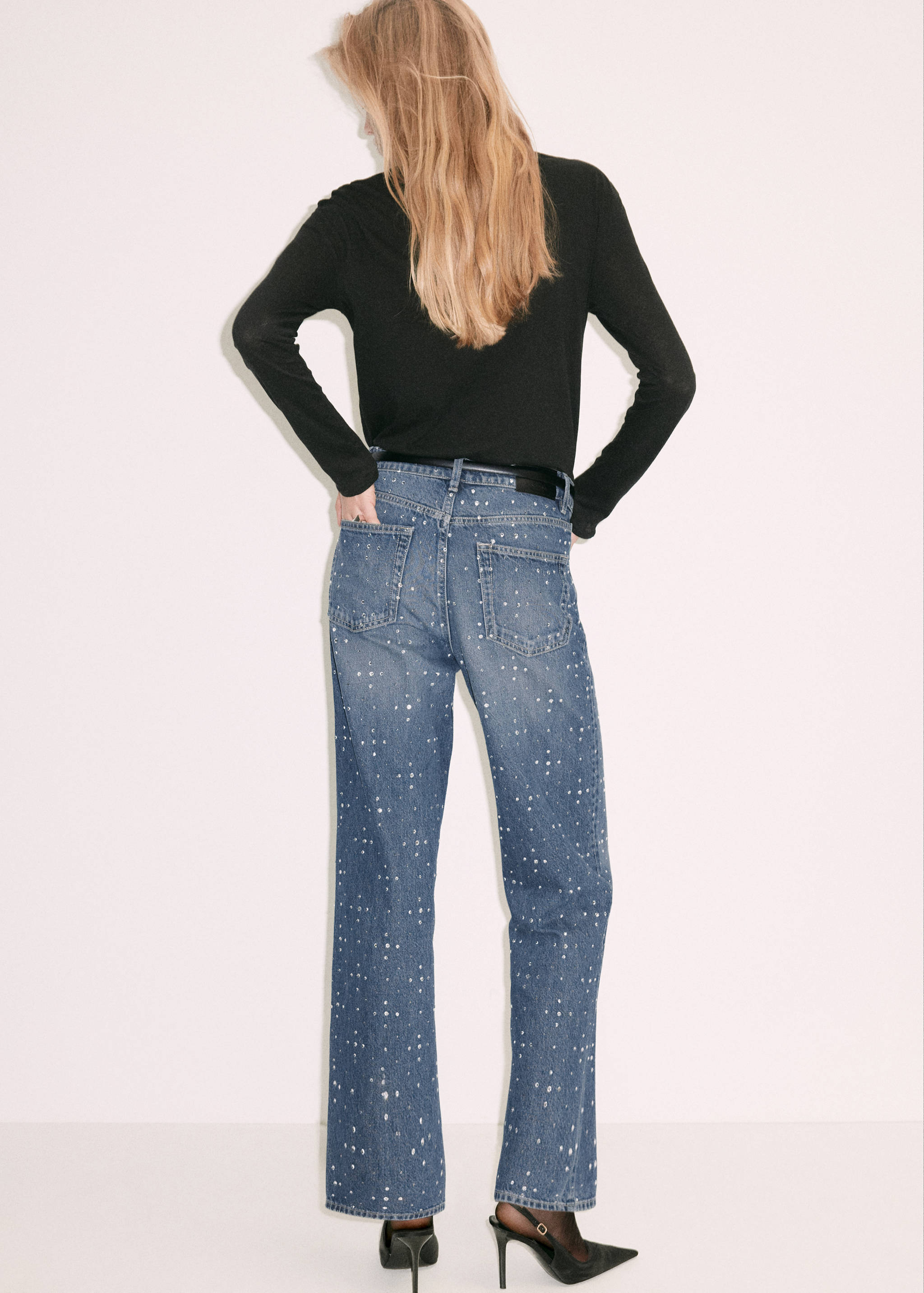 Back view of blue crystal-embellished denim trousers.