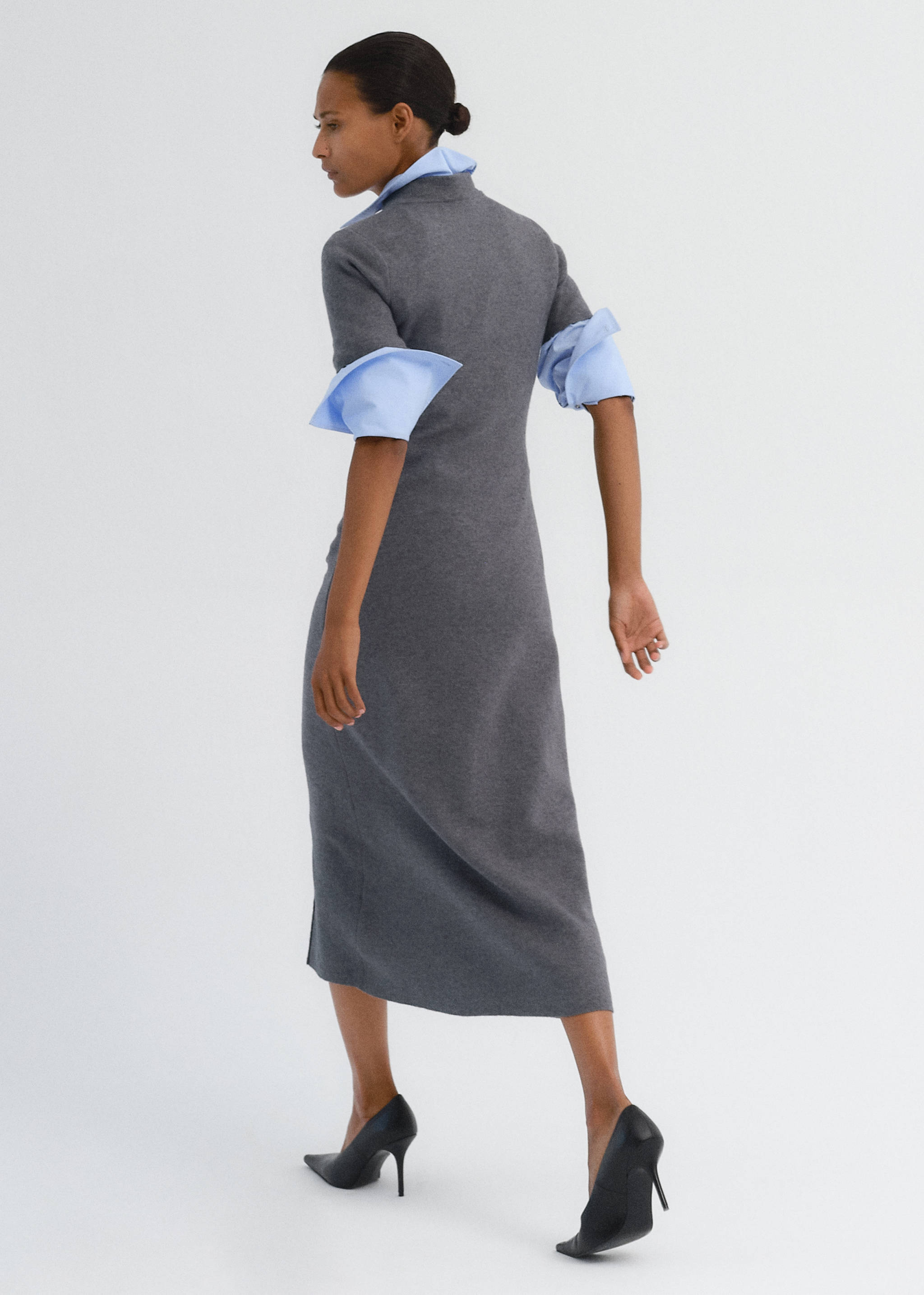 Back view of a grey midi dress layered over a light blue shirt.