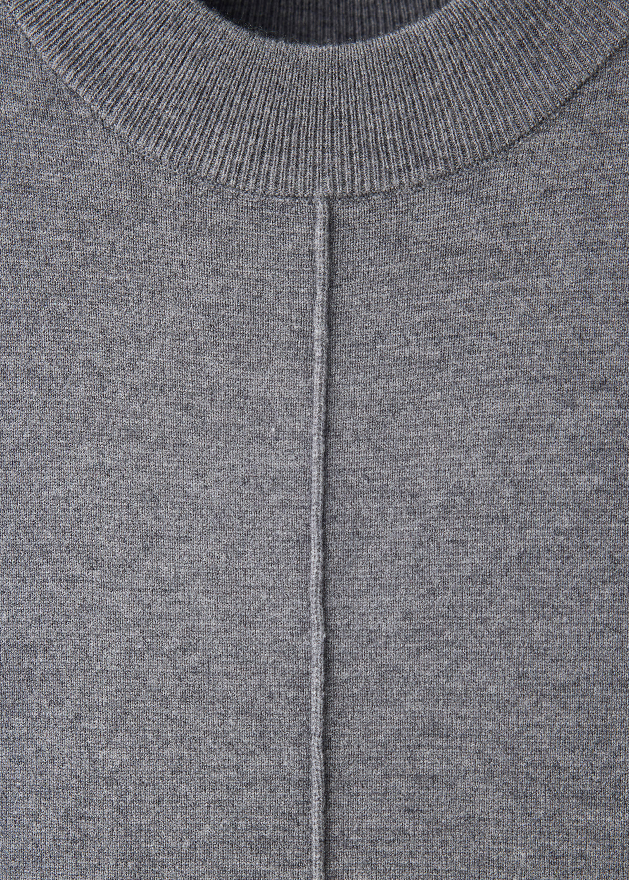 Grey knitted dress detail focusing on the ribbed high neck.