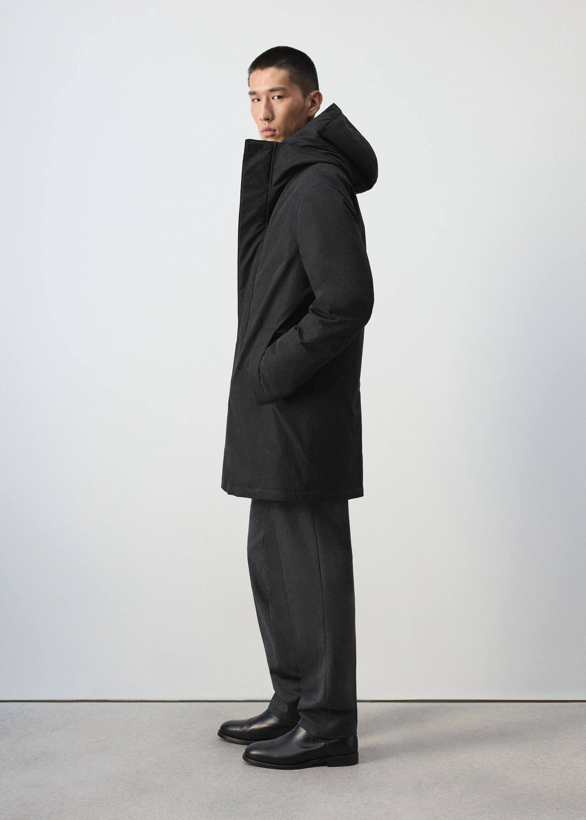 Dark grey hooded parka with high collar and front pockets.