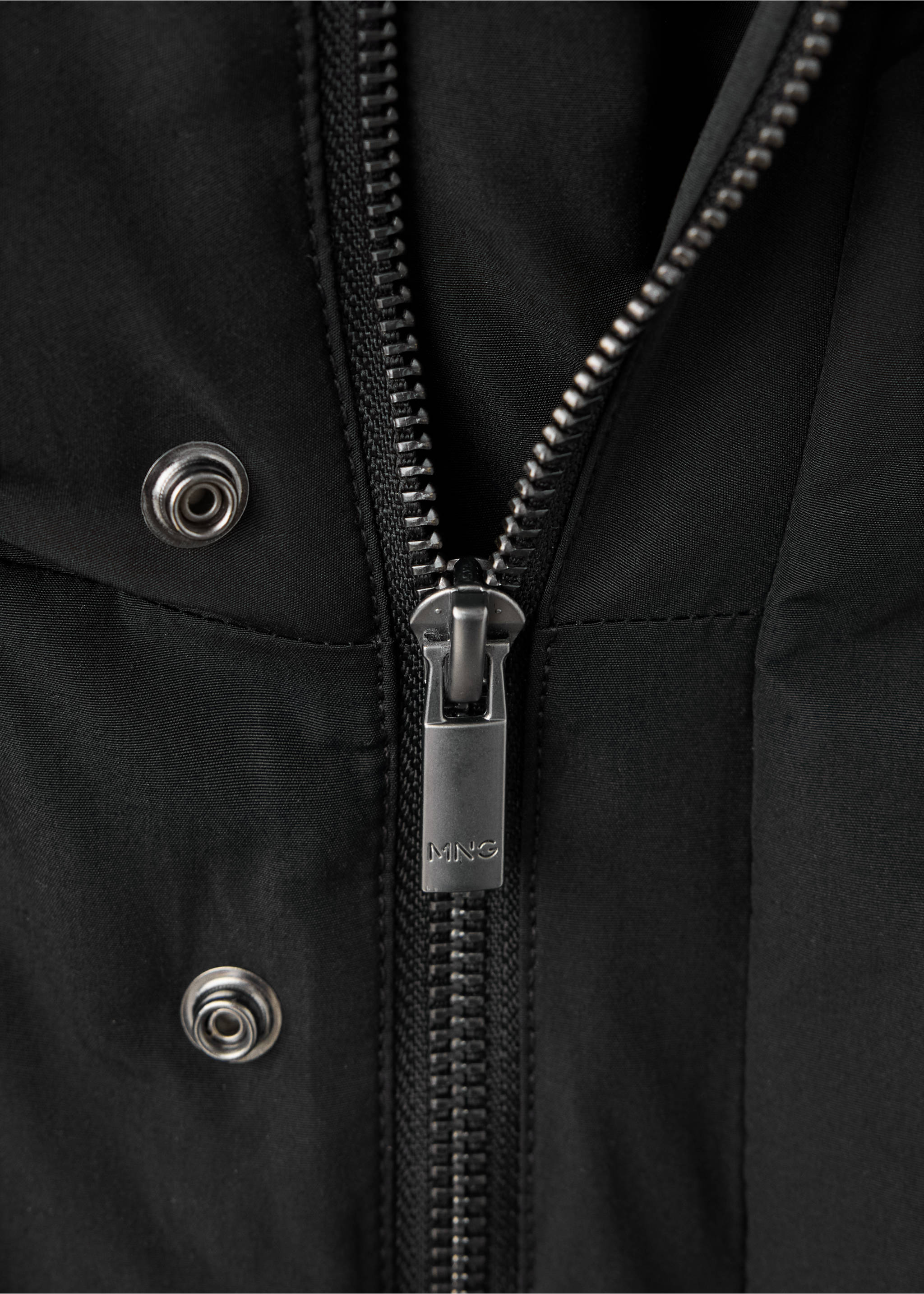 Close-up of a black parka featuring a zipped fastening and metal snap buttons., Black. Ref: 37097882-00.