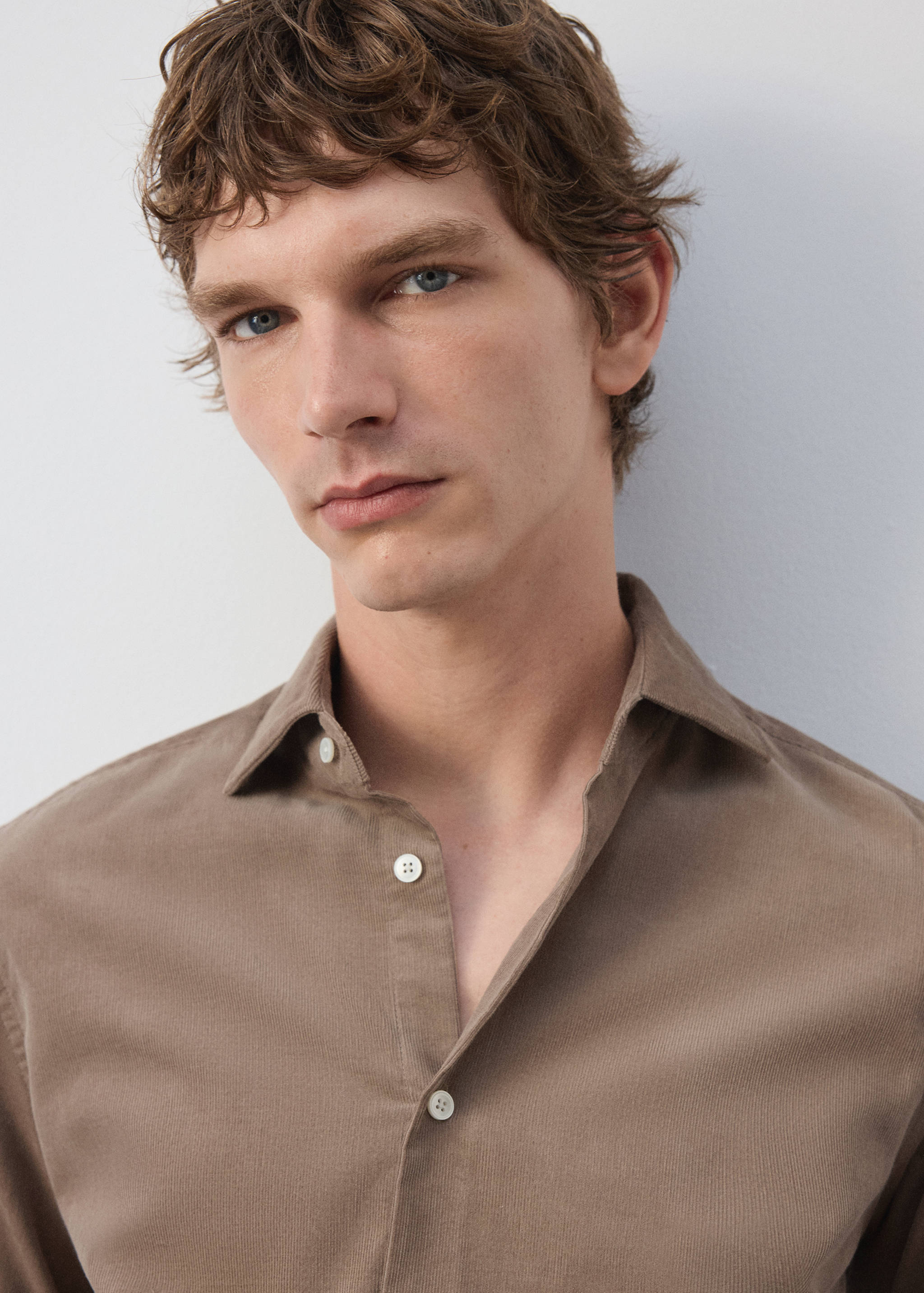 Close-up of a brown collared shirt on a model.