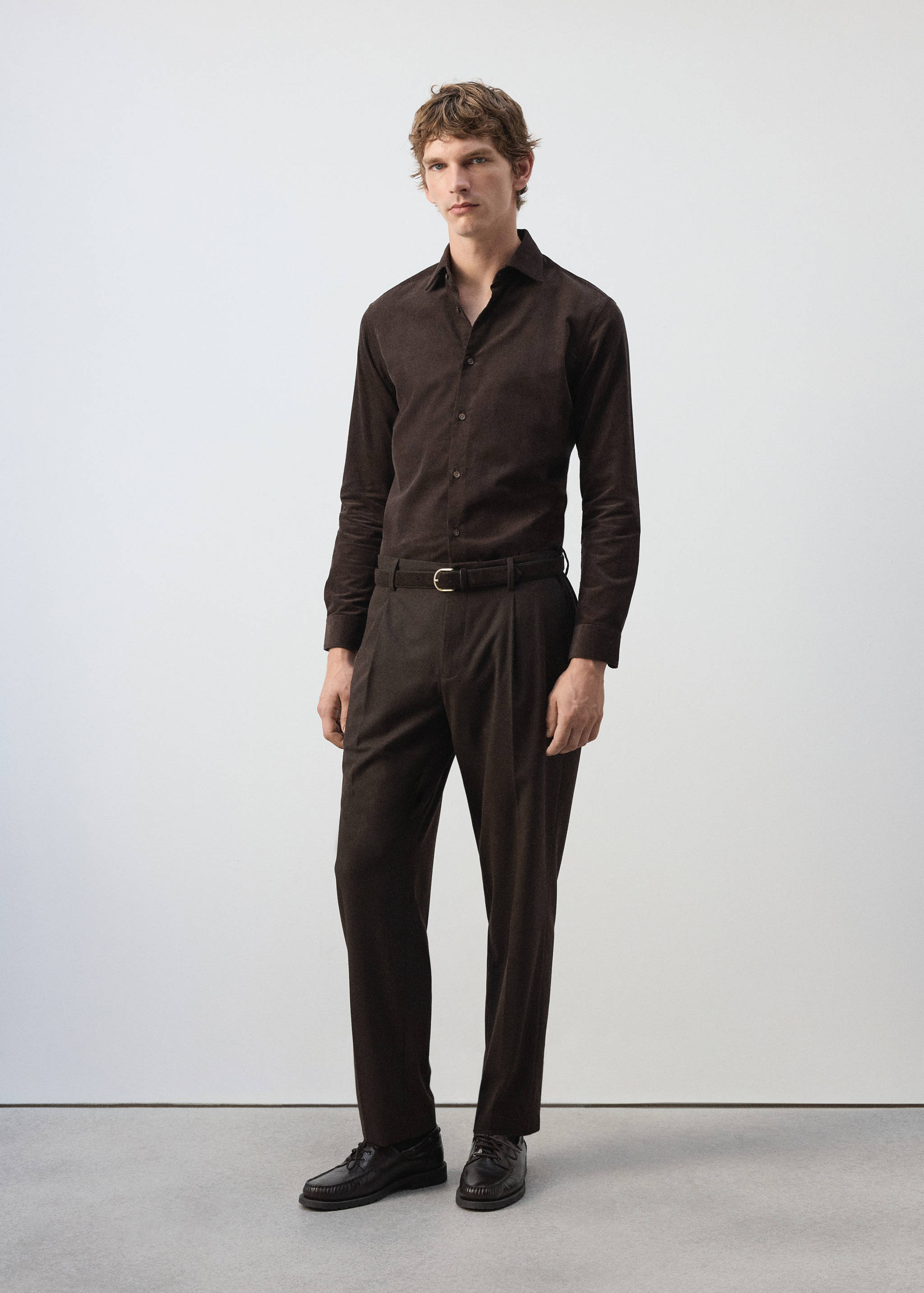 Dark brown long-sleeved shirt with a classic collar and button placket, worn with matching trousers.
