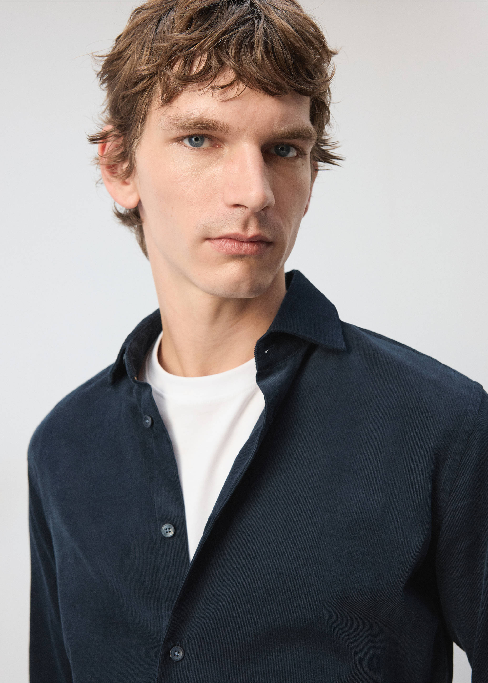 Dark navy blue corduroy shirt with a classic collar, worn over a white t-shirt., Dark Navy. Ref: 37097883-00.