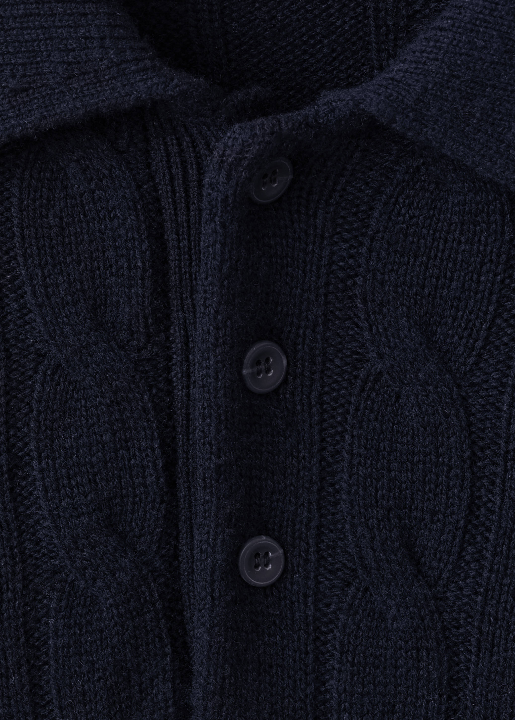 Close-up of a dark navy blue cable-knit polo shirt with a button placket.