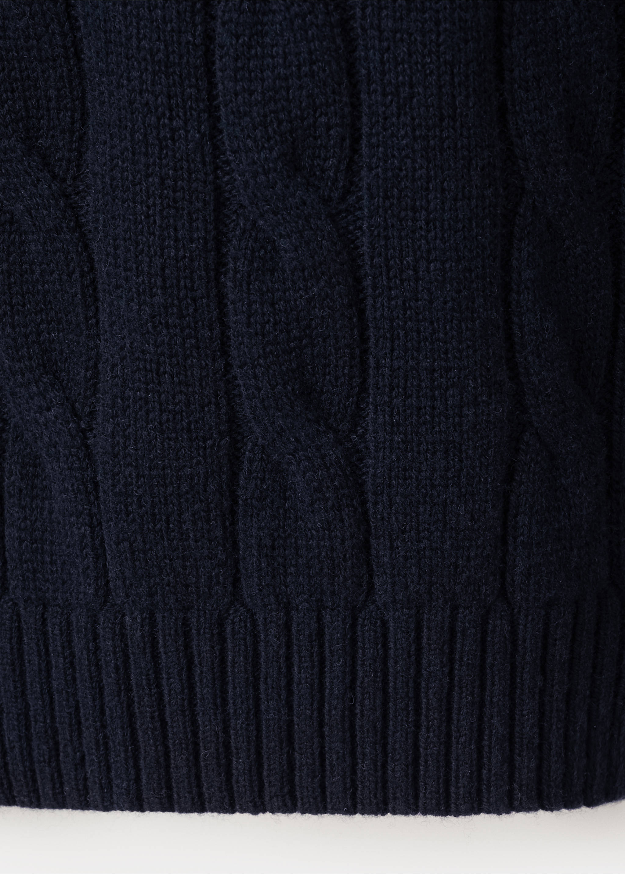 Close-up of the dark navy blue cable-knit fabric and ribbed hem of a polo., Navy. Ref: 37097885-00.
