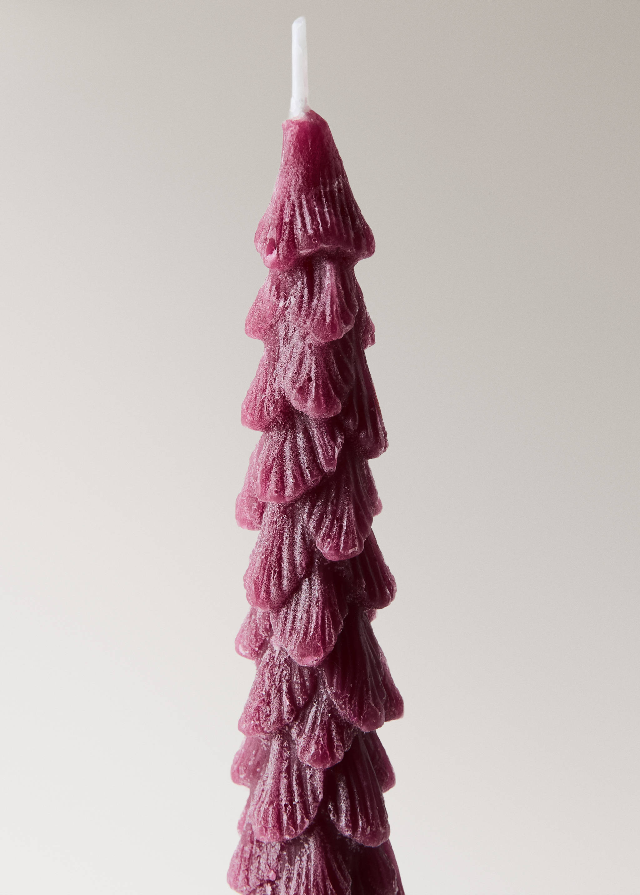 Burgundy pine tree-shaped candle with textured overlapping layers.