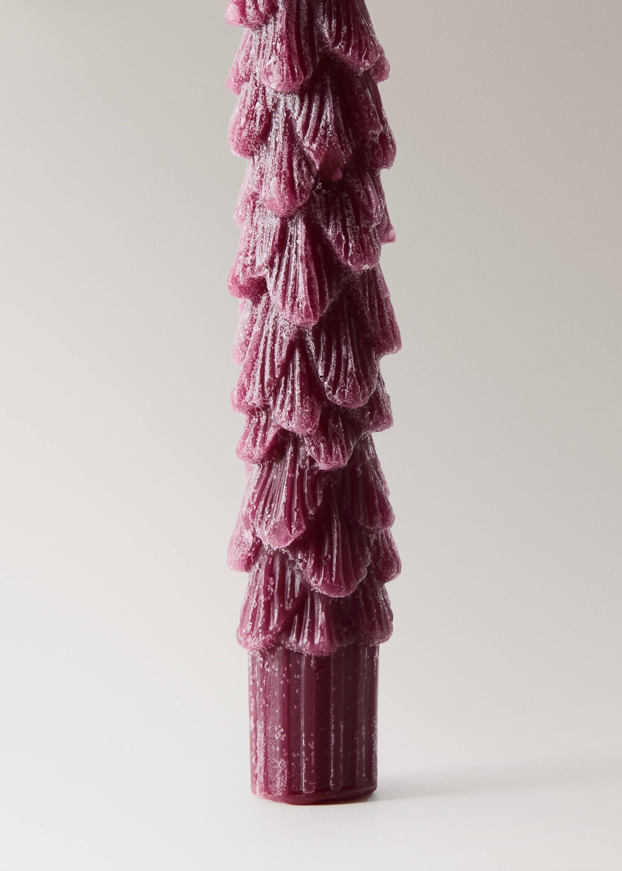 Plum candle with a textured, layered pine needle design.