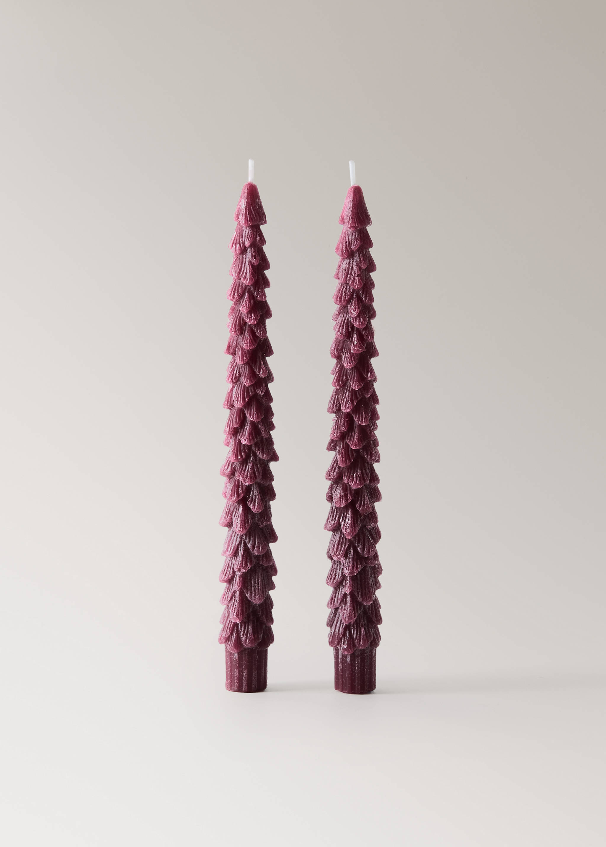 Two dark pink plum-coloured tree-shaped candles with textured layers.