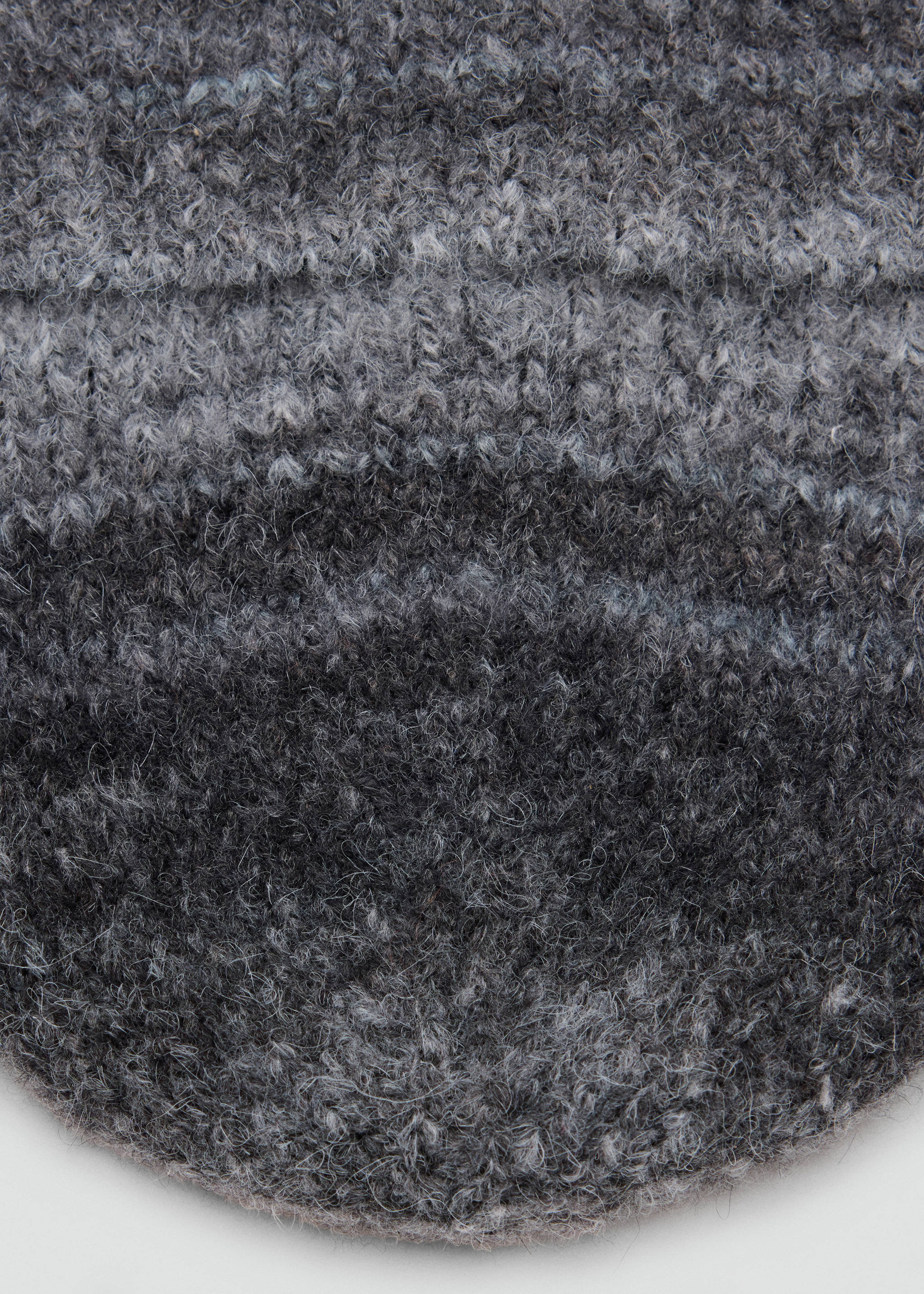 Close-up of a grey knit children's beanie with a fuzzy textured finish.