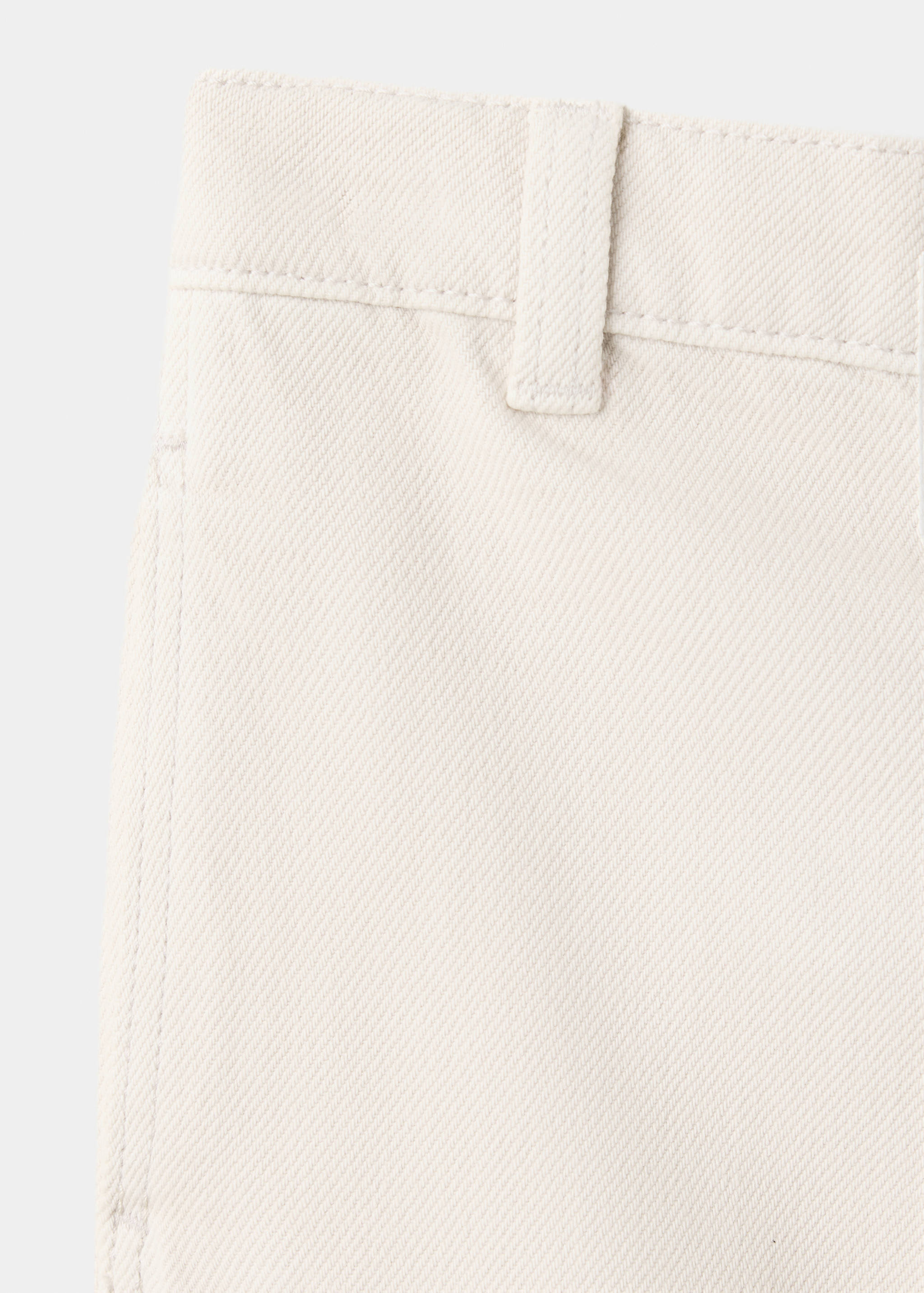 Off-white trousers fabric detail showing twill texture.