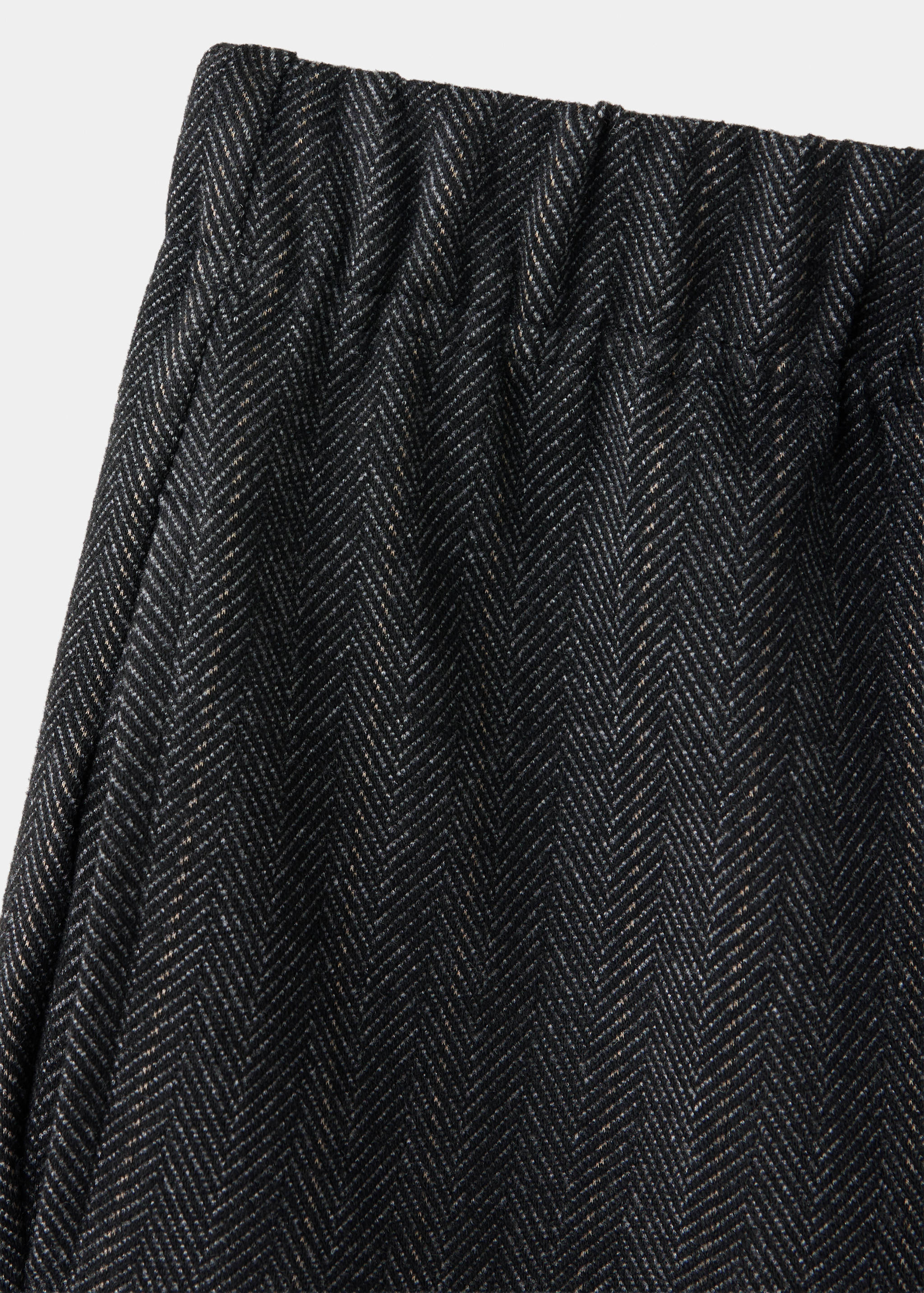 Close-up of children's dark herringbone trousers with an elasticated waist.