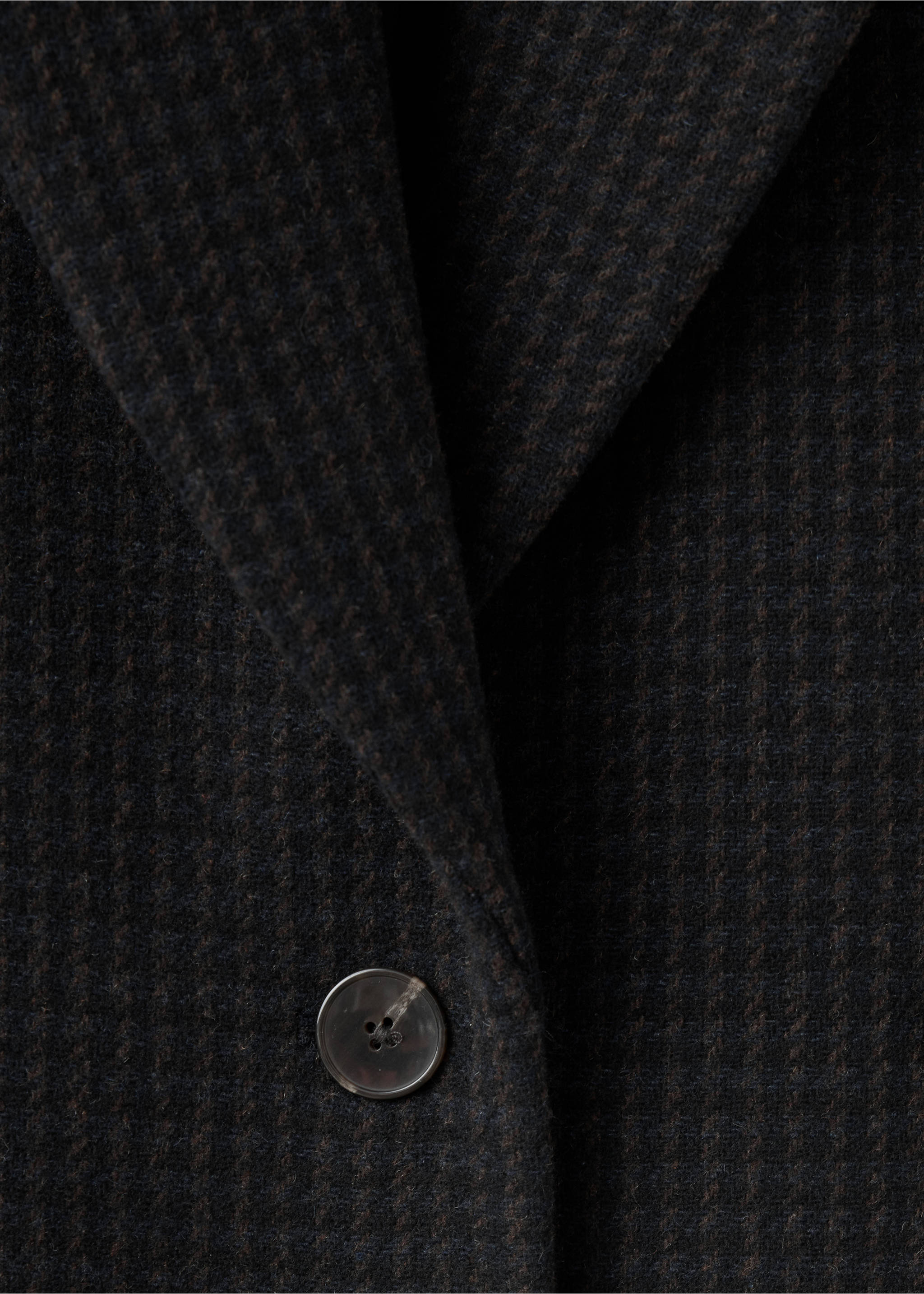 Close-up of a charcoal grey houndstooth blazer lapel and button., Blue. Ref: 37097912-00.