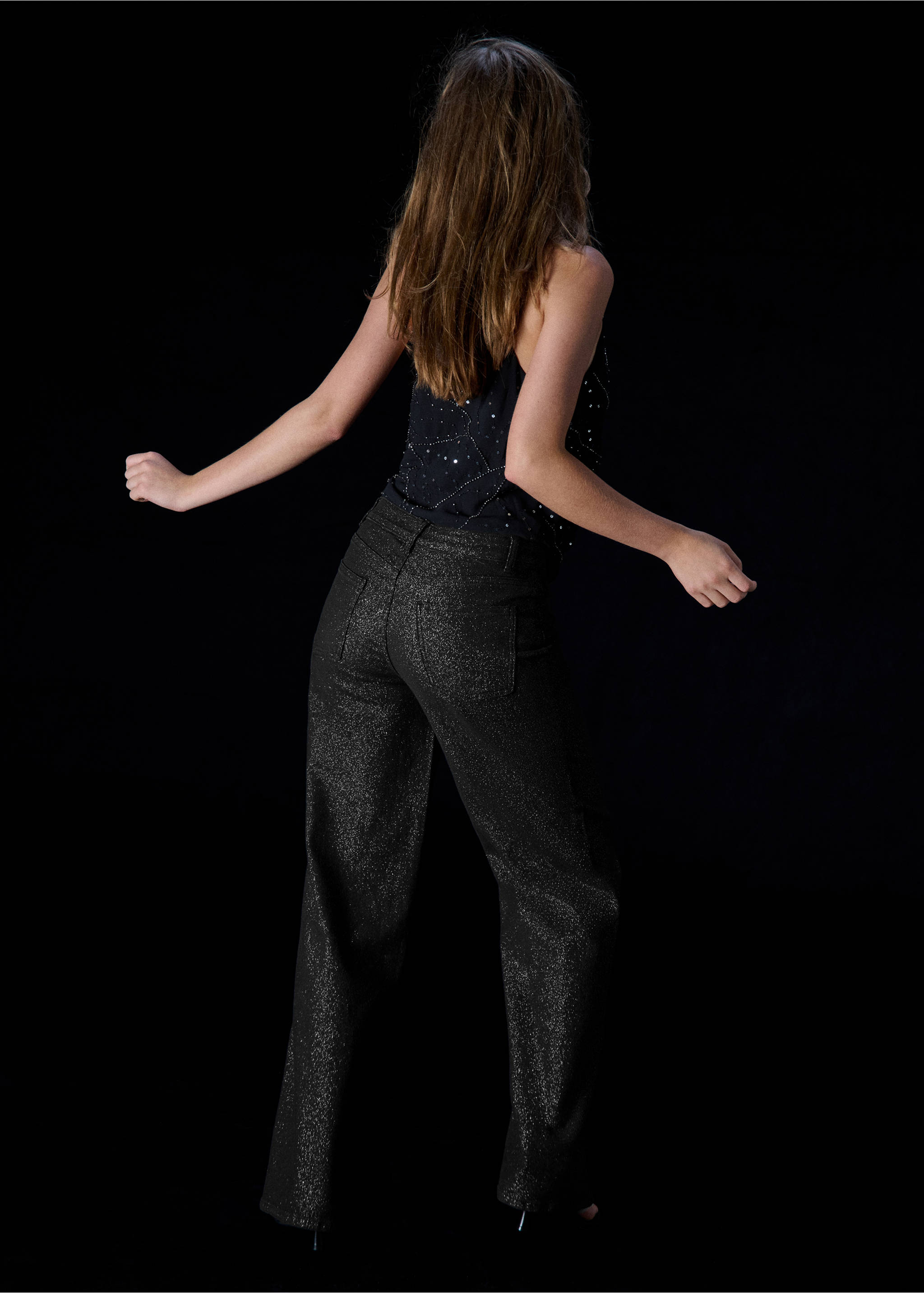 Black glitter trousers shown from the back, paired with a dark embellished top., Black. Ref: 37097915-01.