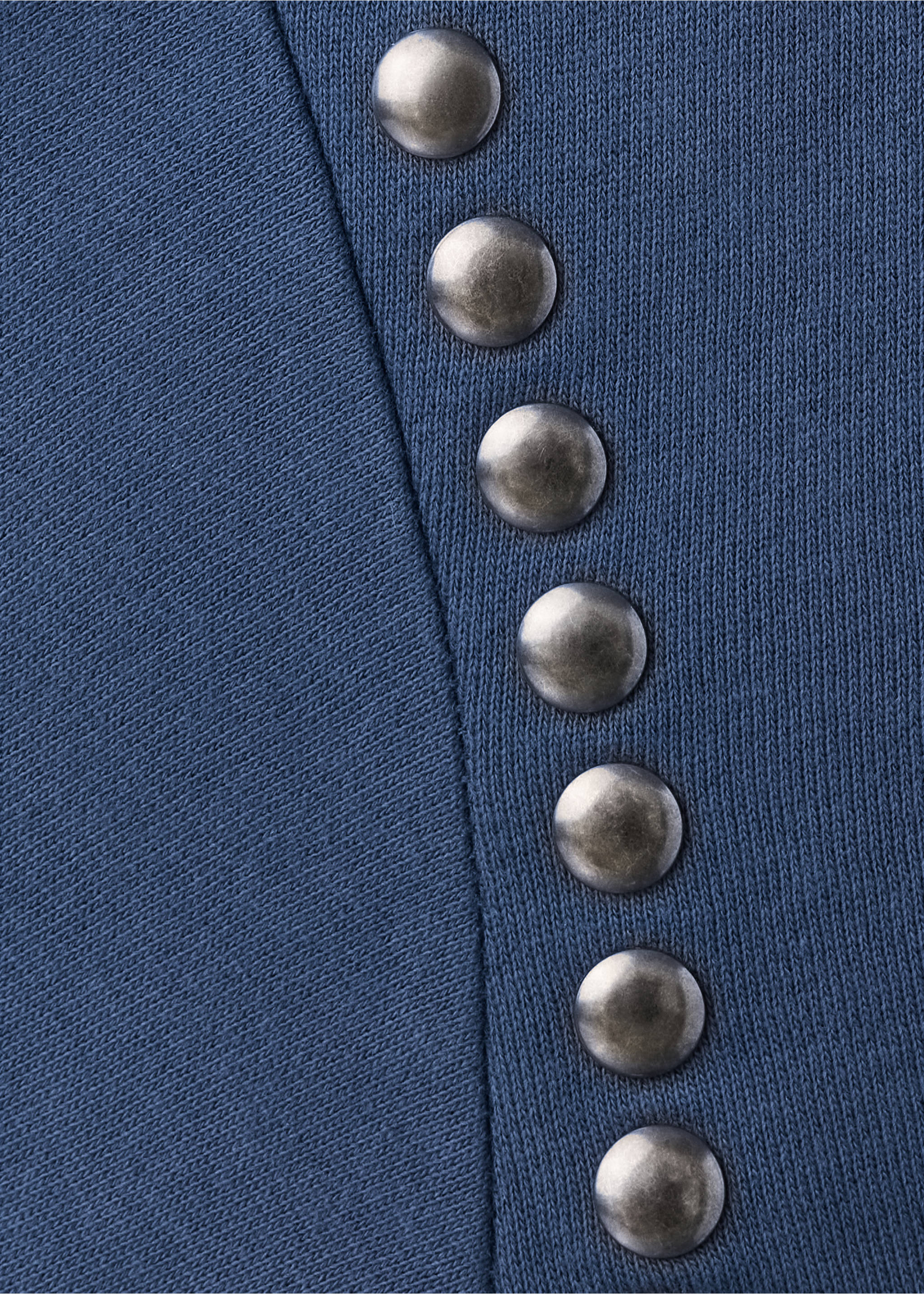 Primer plano de tejido de sudadera azul con una hilera de tachuelas metálicas., Azul. Ref: 37097929-00.