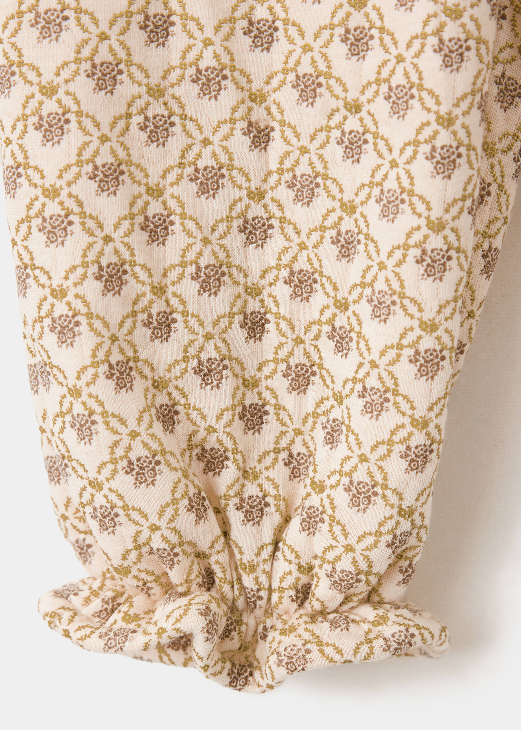 Close-up of fabric detail on kids' floral joggers with an elasticated cuff.