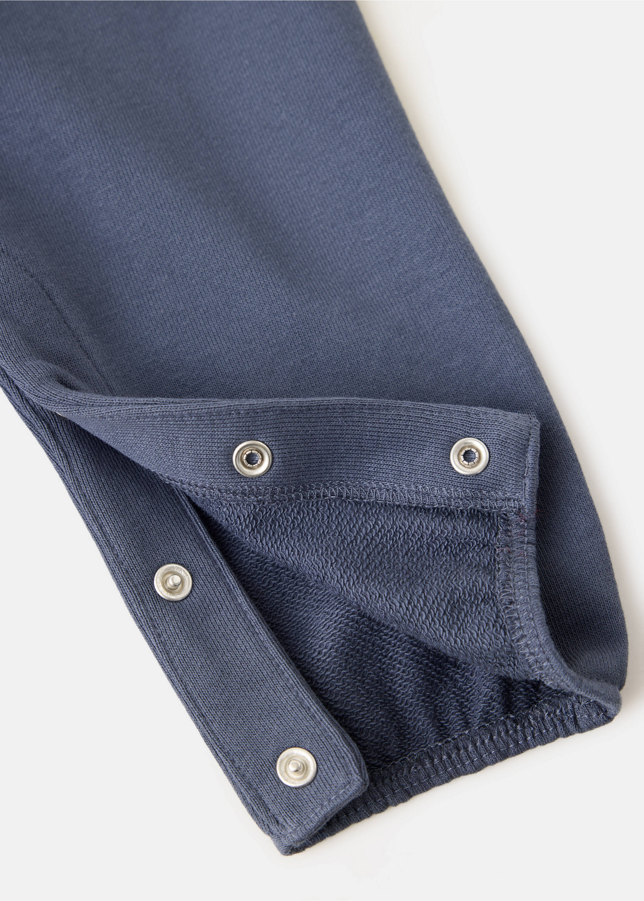 Close-up of navy blue baby dungaree fabric with snap fasteners., Navy. Ref: 37097936-00.