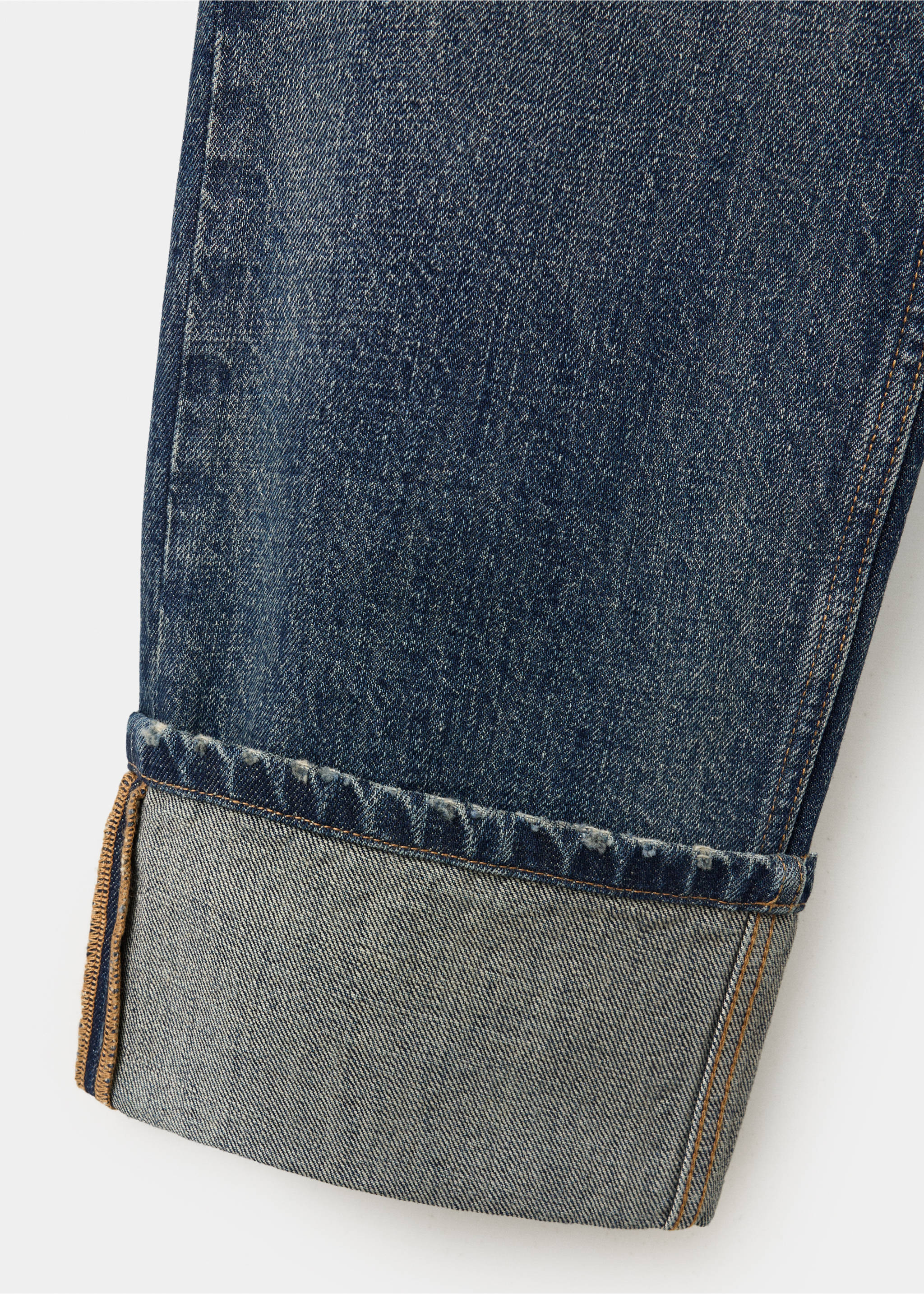 Close-up of blue denim trousers featuring a turned-up cuff and contrast stitching., Dark Blue. Ref: 37097937-00.