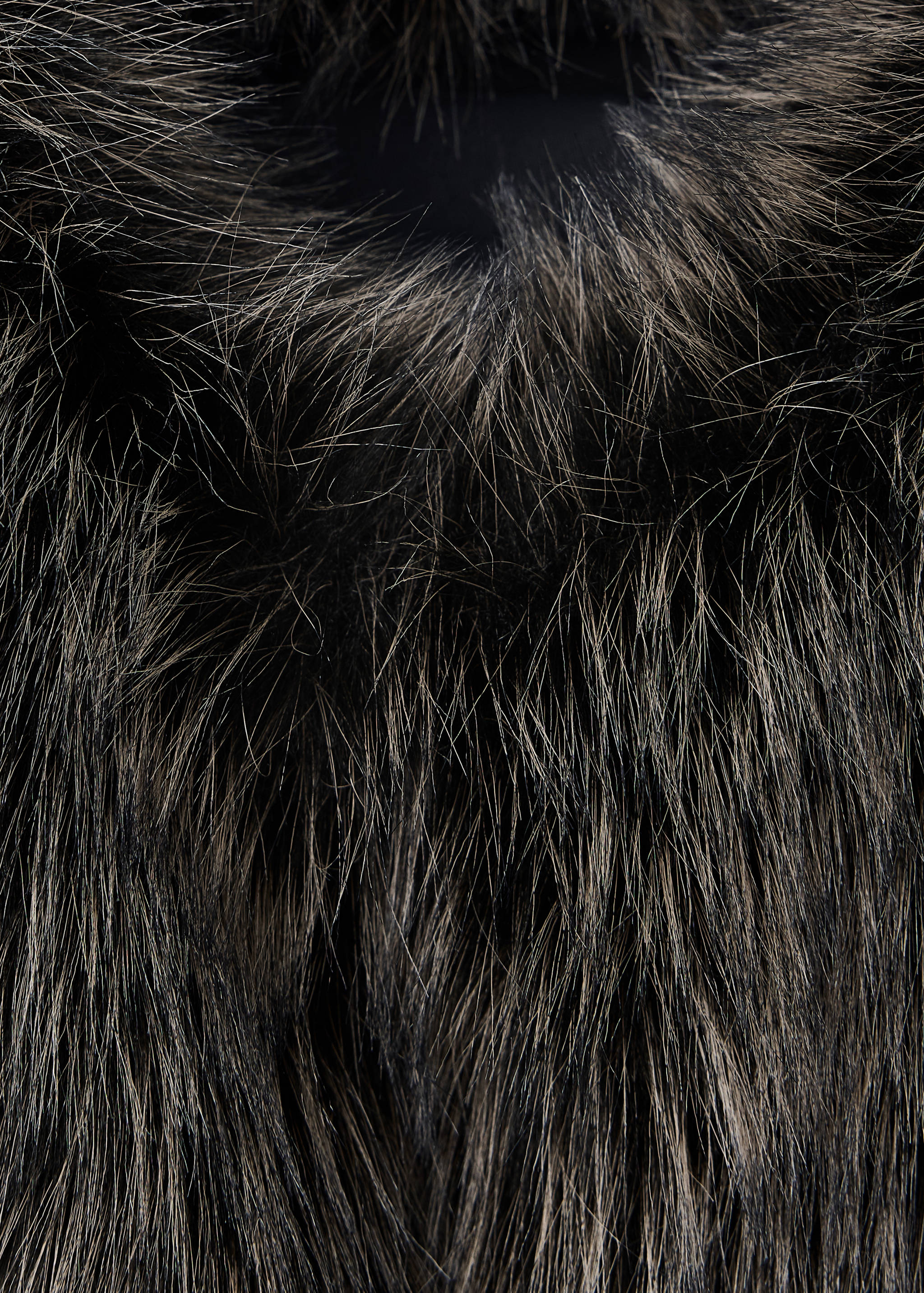 Close-up of a dark brown and grey faux-fur vest texture.