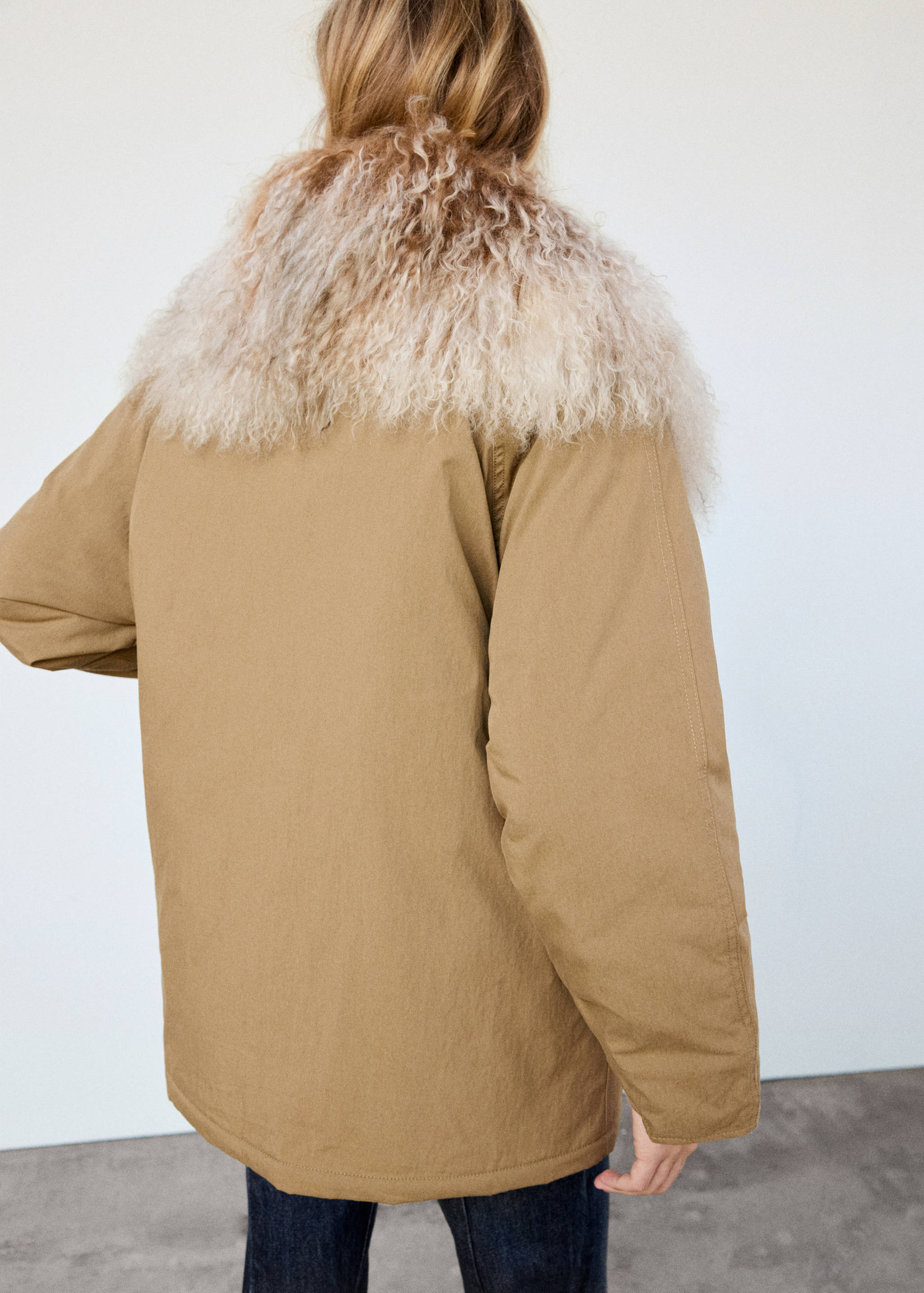 Camel parka with a cream faux-fur collar, back view.