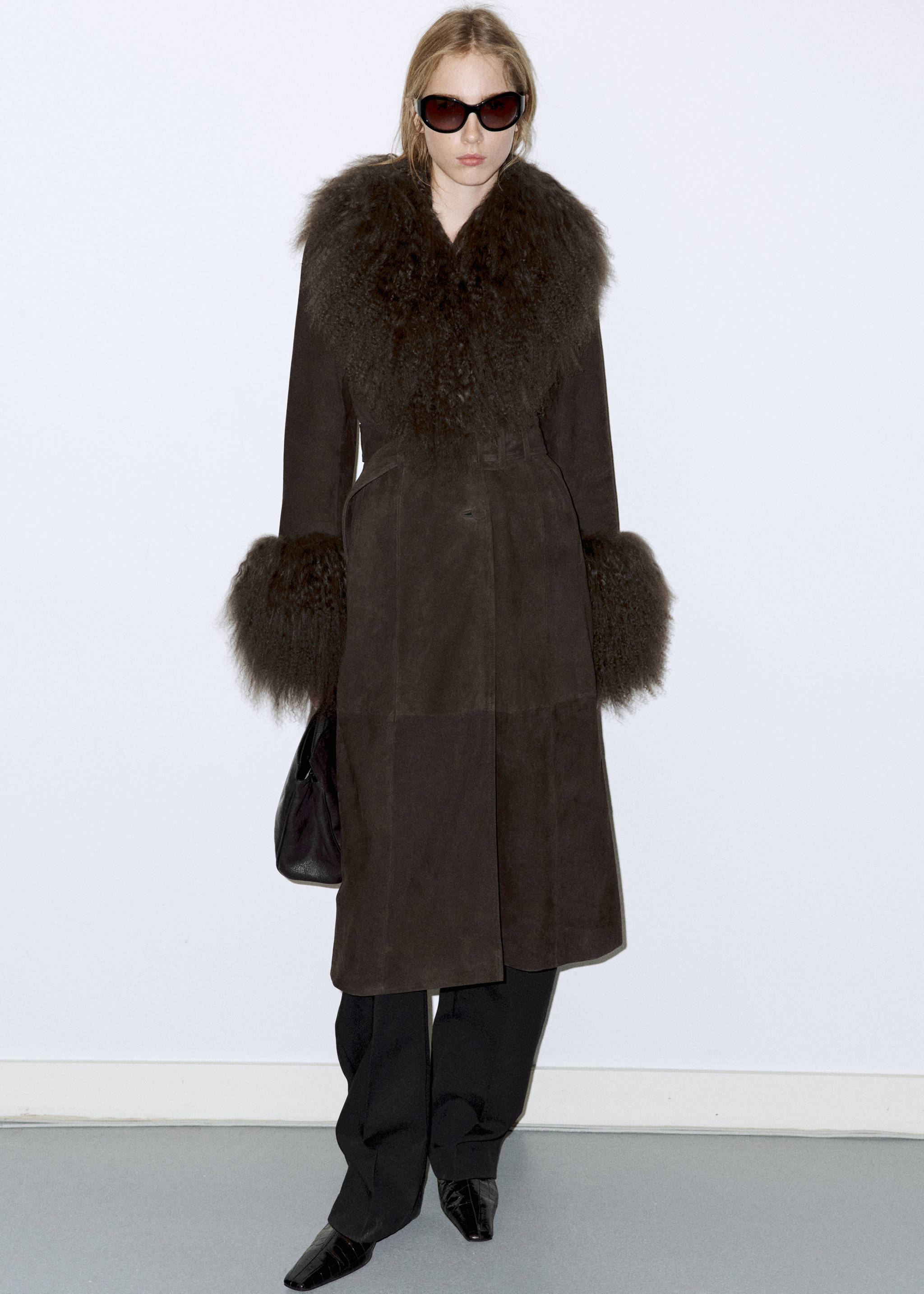 Dark brown long coat with voluminous faux-fur collar and cuffs.